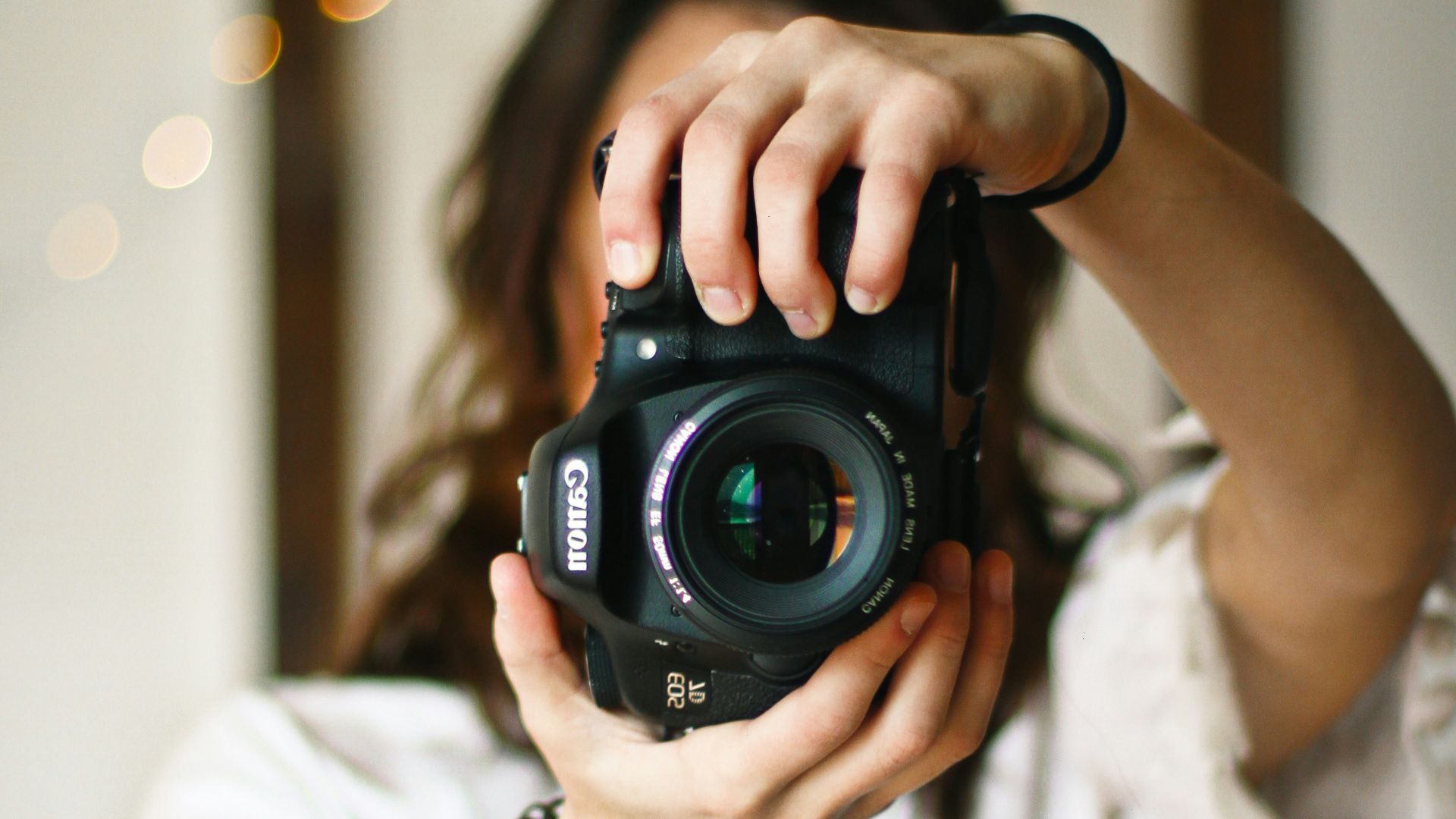 woman holding black DSLR camera