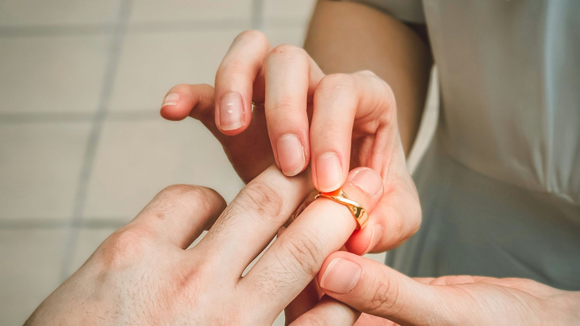 a man putting a wedding ring on a woman's finger