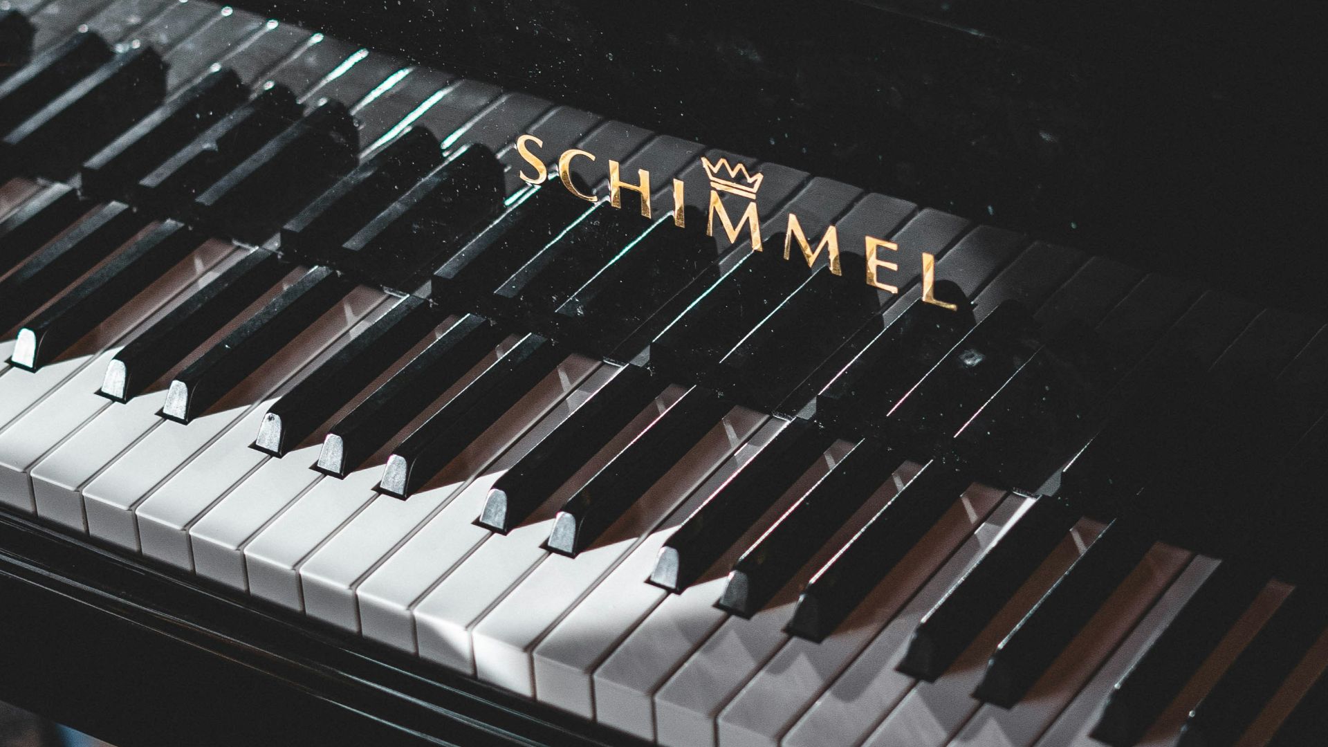 a close up of a black piano with the word schimmel on it