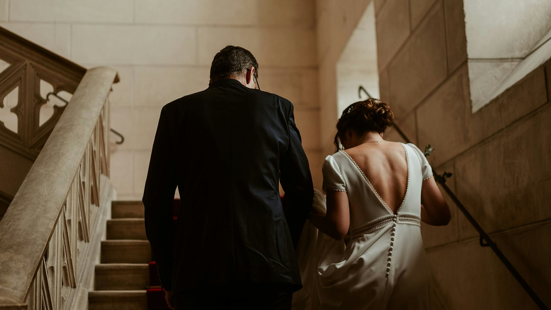 A bride and groom walking down a flight of stairs