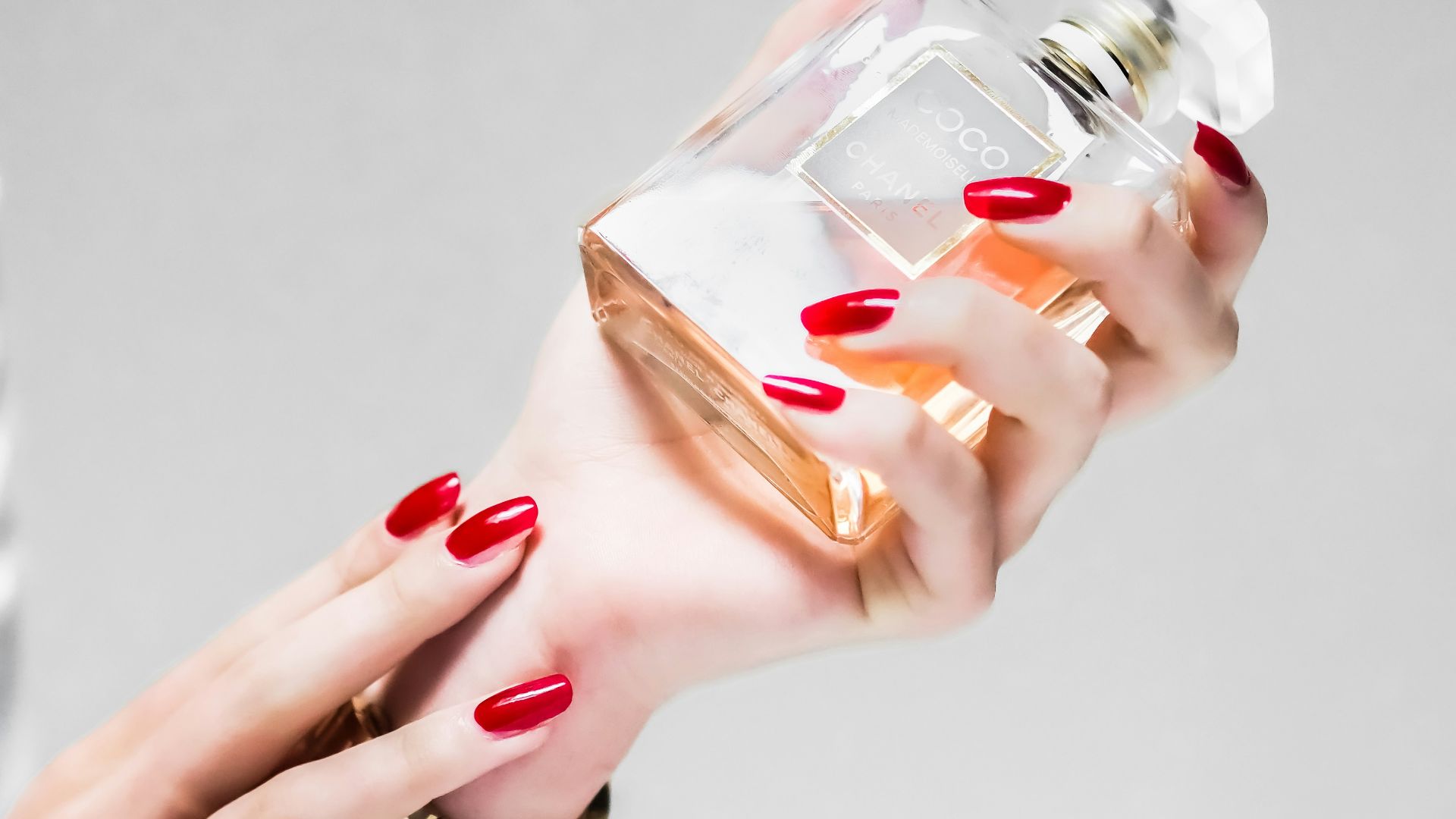 person holding clear glass bottle