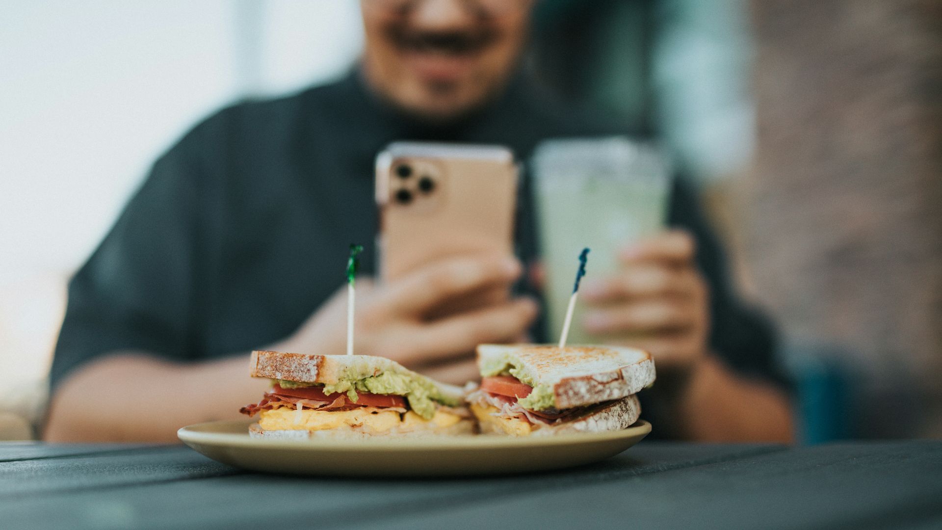 man in gray sweater holding silver iphone 6