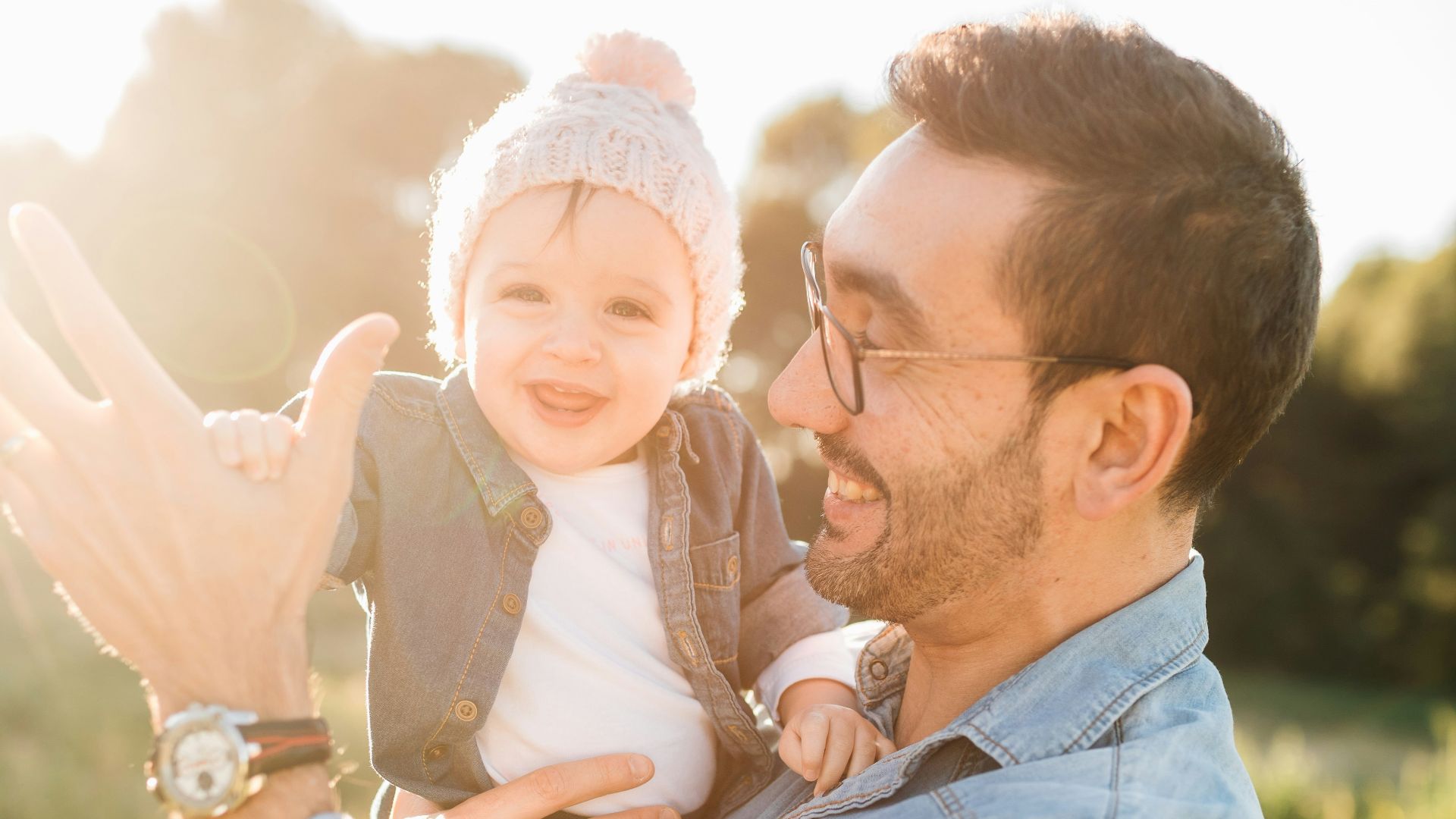 man in blue denim jacket carrying girl in white sweater during daytime