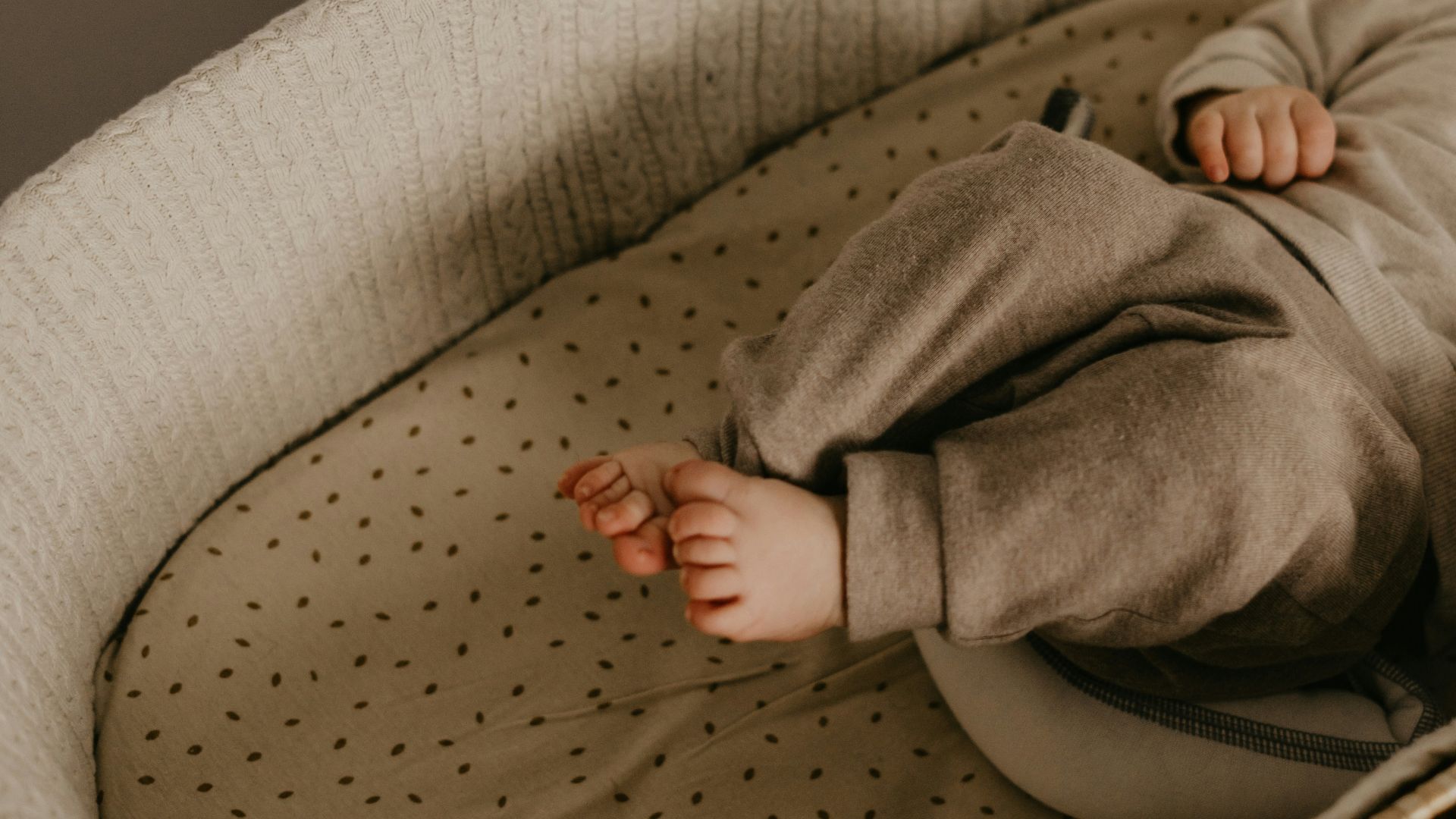 a baby laying in a crib with a handbag on top of it