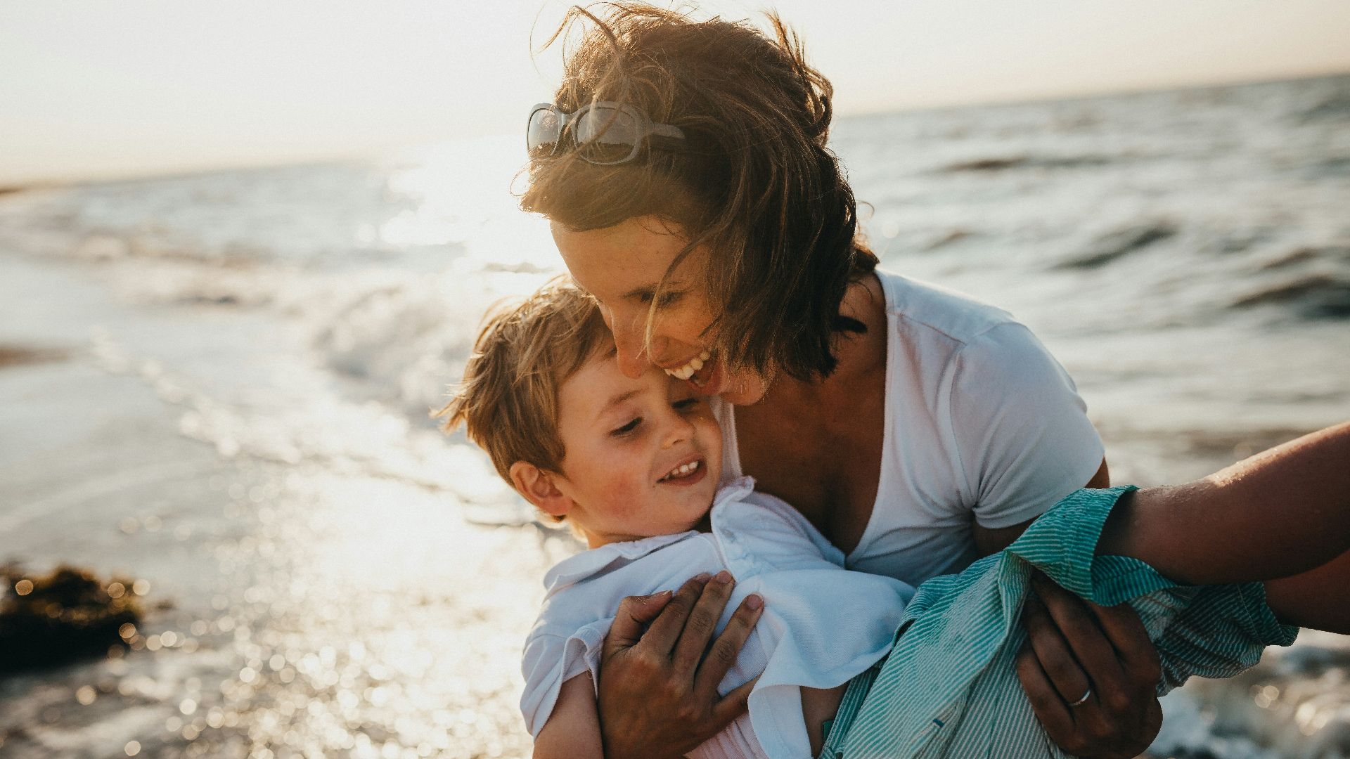 photo of mother and child beside body of water