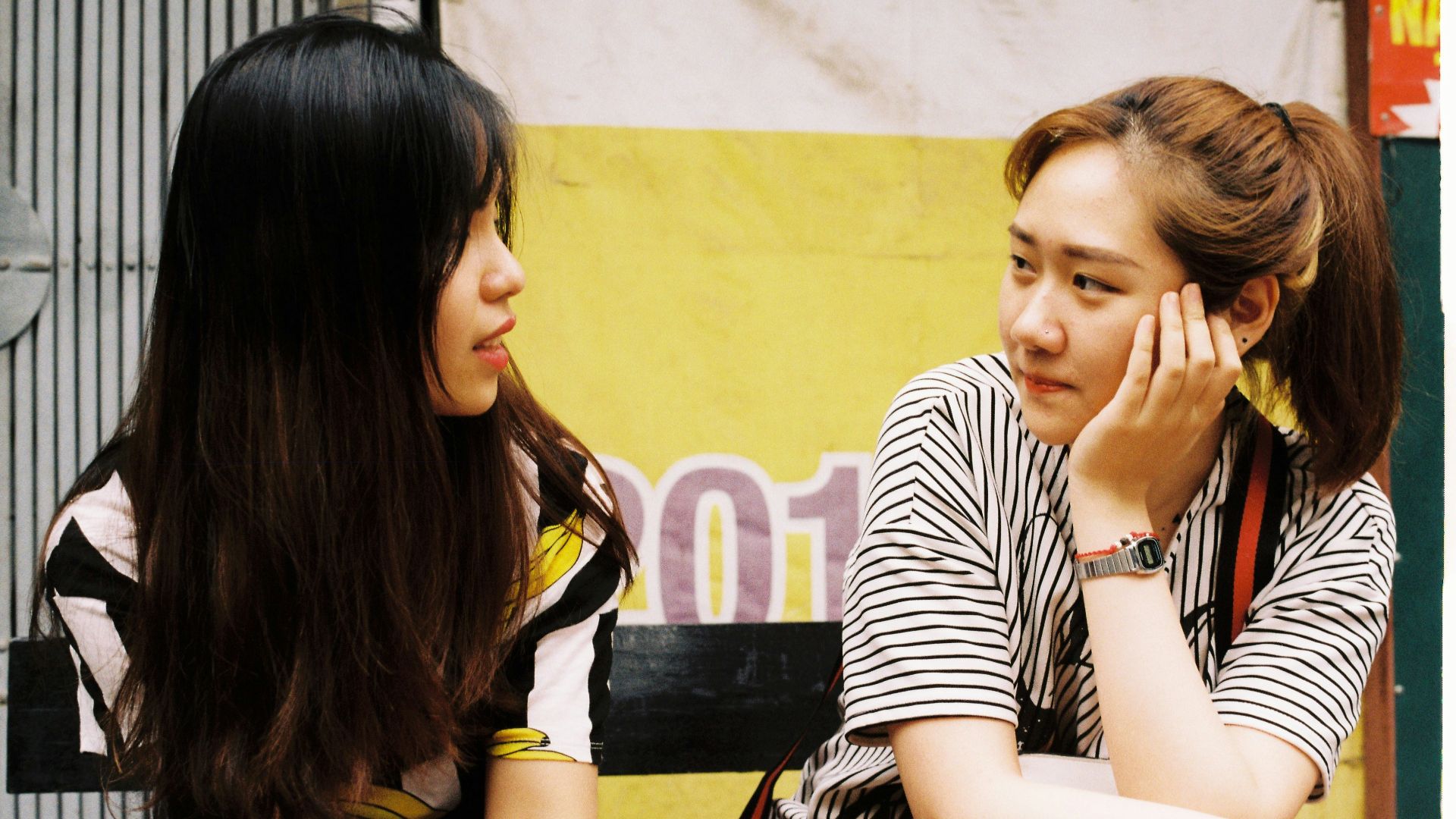 woman in white-and-black striped tops looking each other
