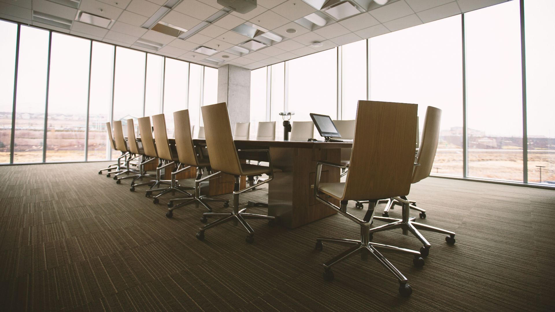 oval brown wooden conference table and chairs inside conference room