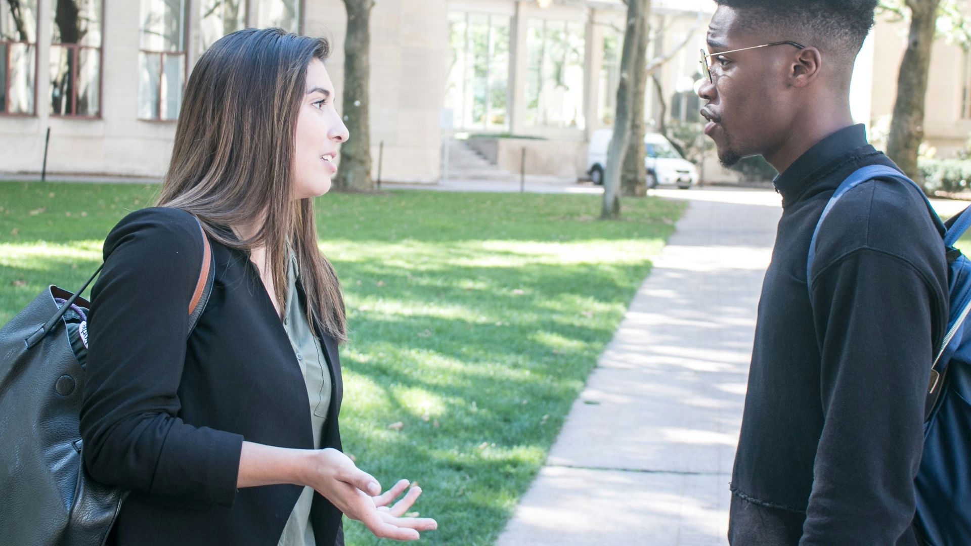 a man standing next to a woman on a sidewalk