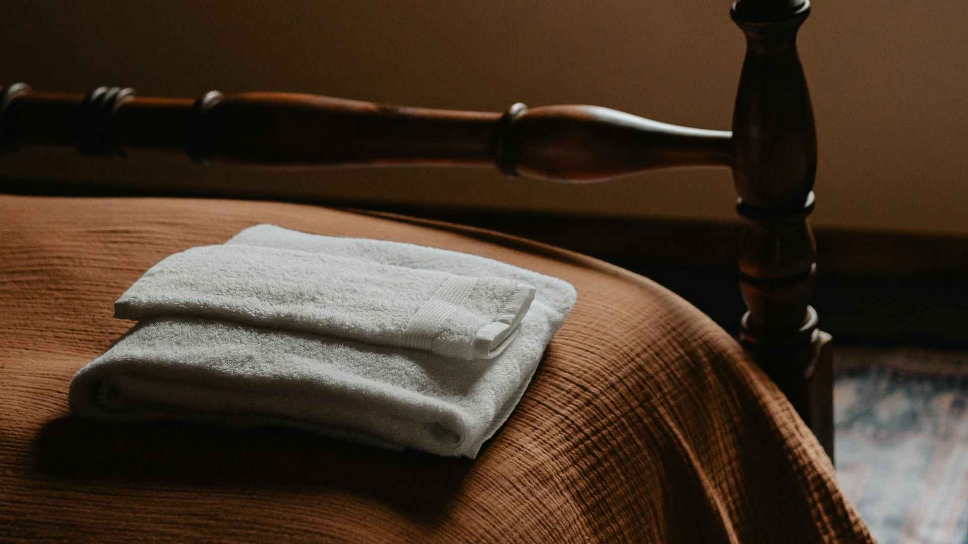 a bed with a blanket and a wooden head board