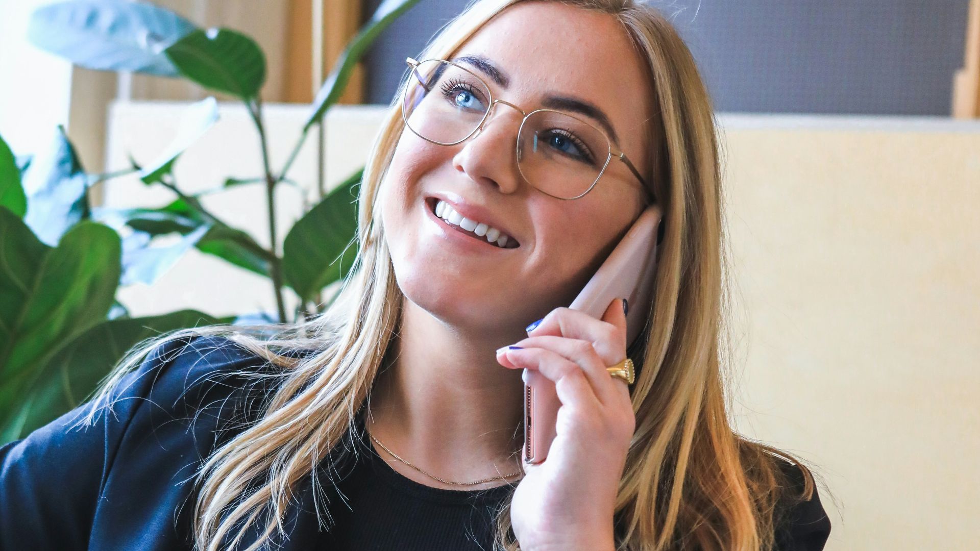 woman in blue long sleeve shirt sitting on brown couch