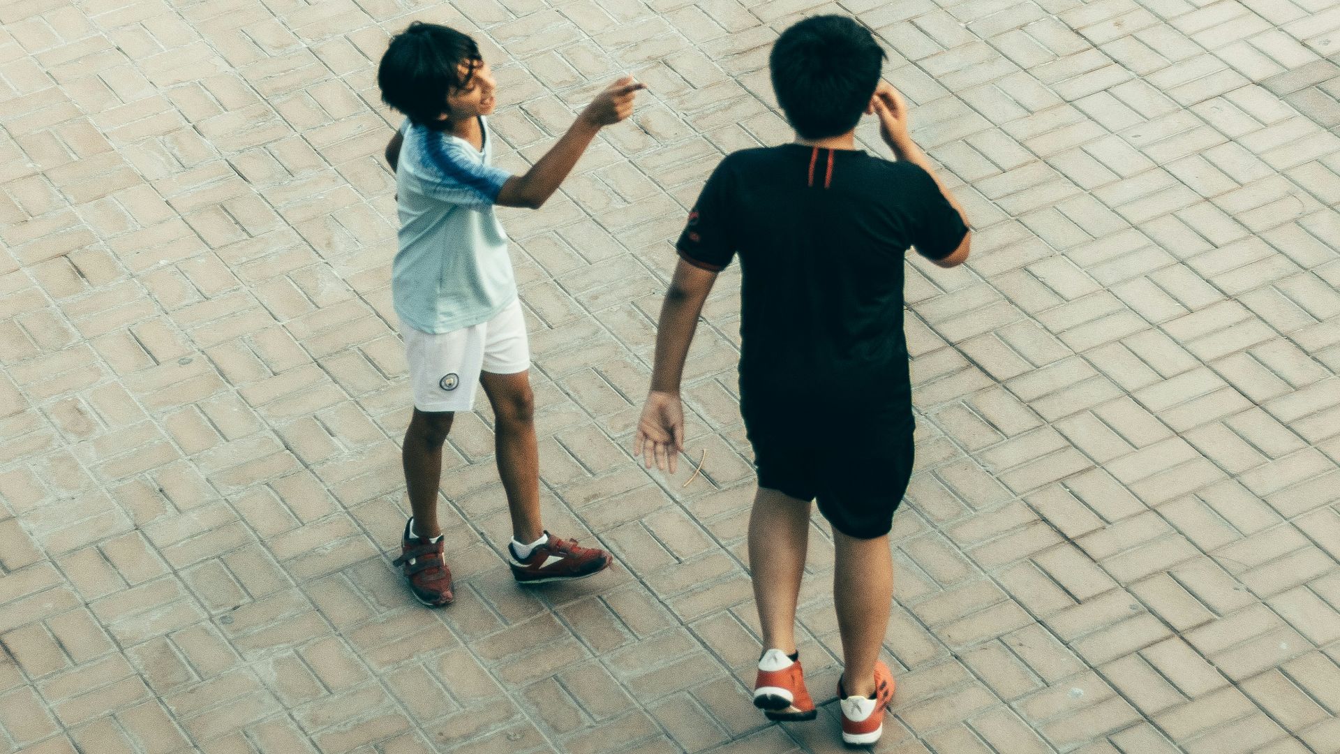 a man and a boy standing on a brick walkway