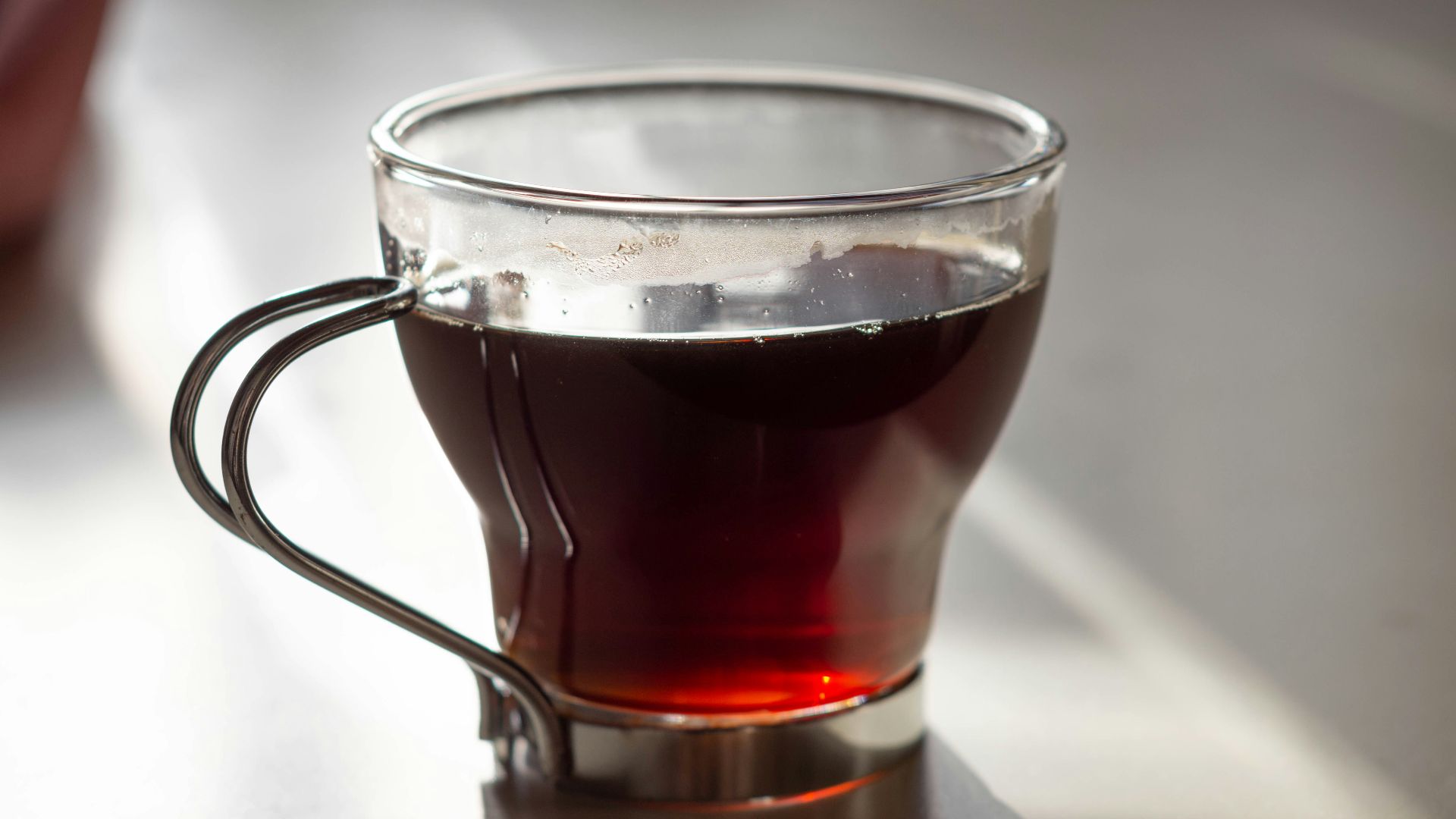 clear glass mug with brown liquid