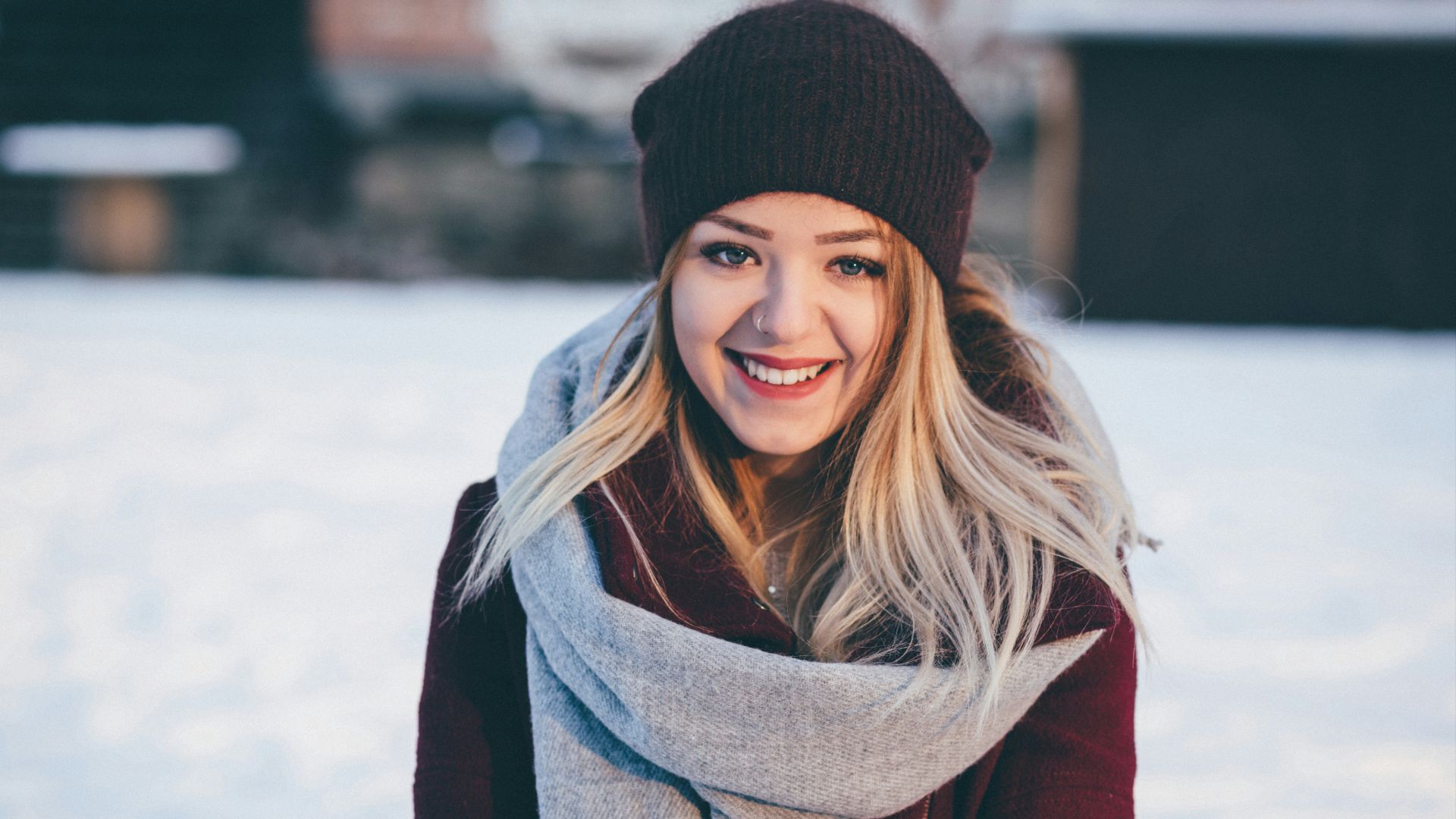 smiling woman wearing brown scarf and maroon coat on snow field