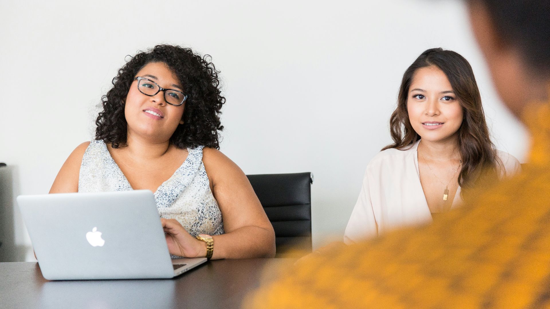 two women looking at person across the table