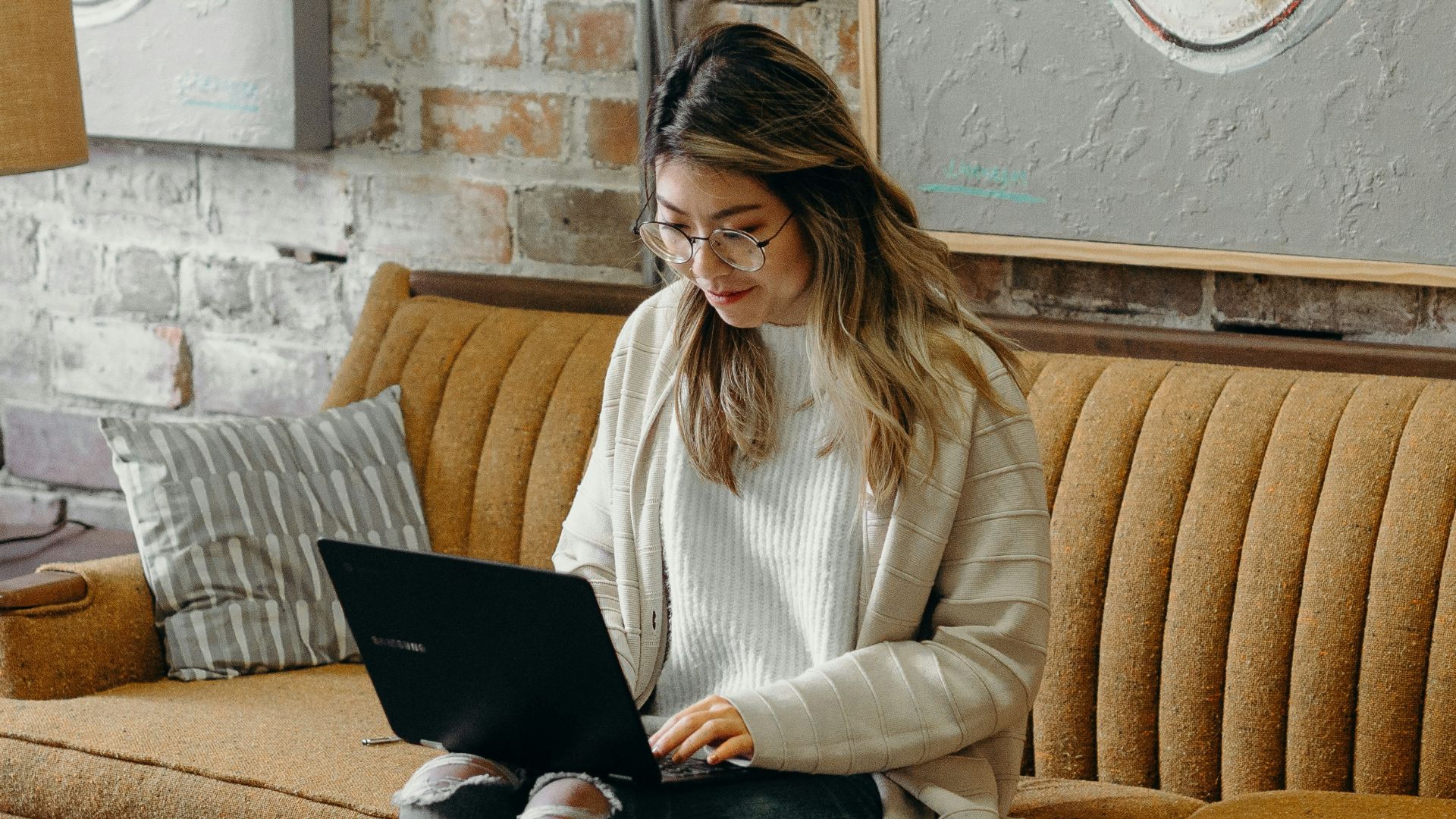 woman using laptop while sitting on chair