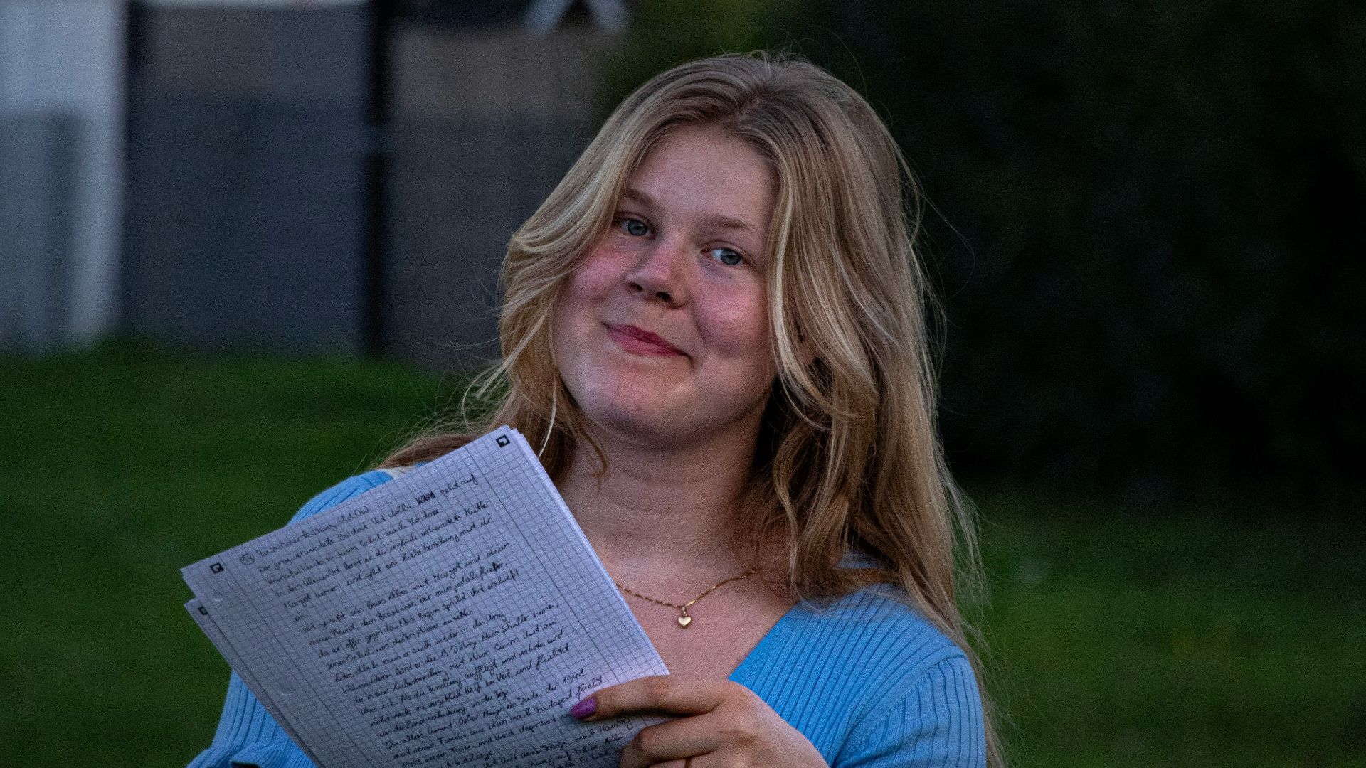 a woman in a blue shirt is holding a book