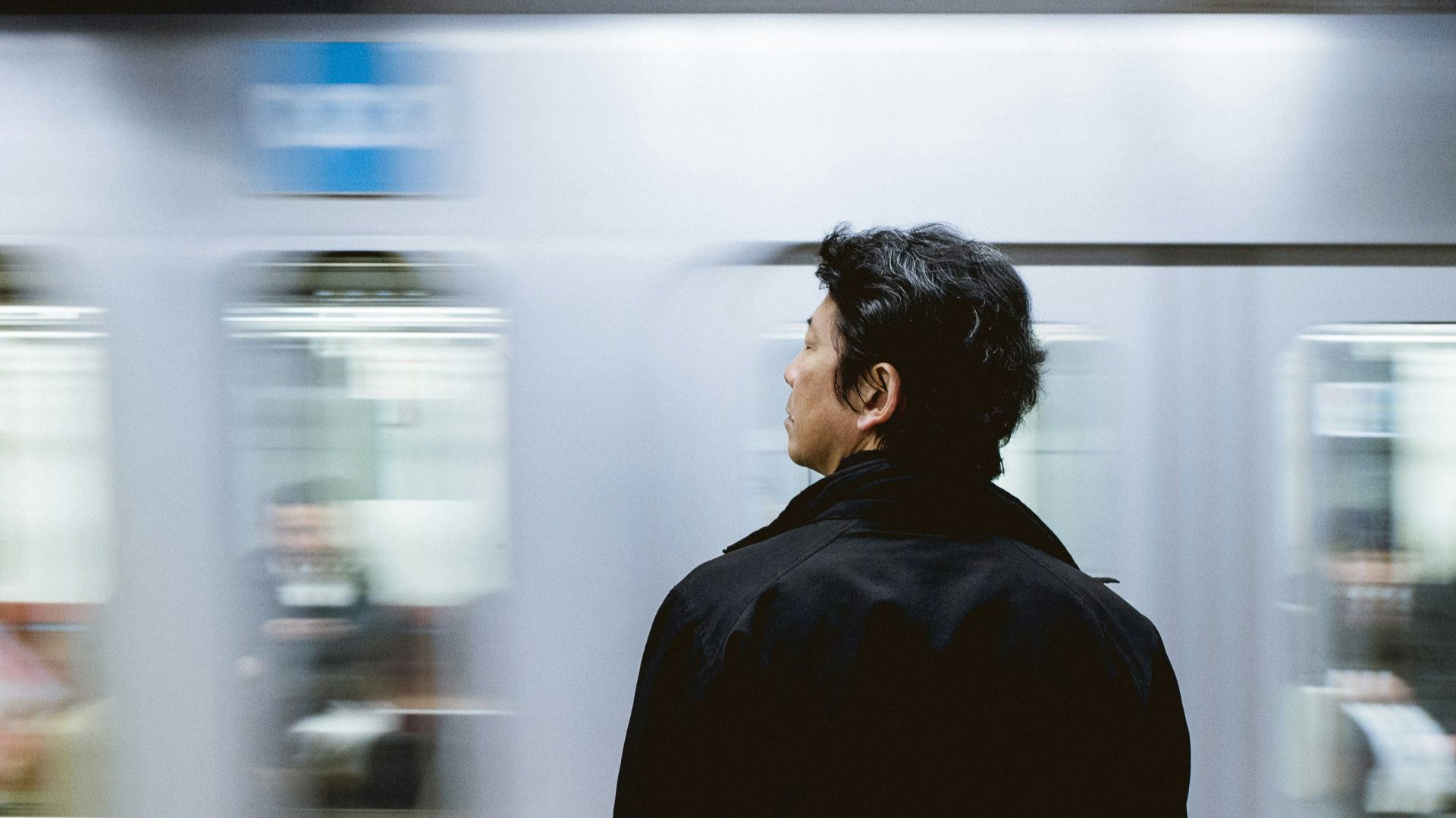 close-up photography of man standing front of train