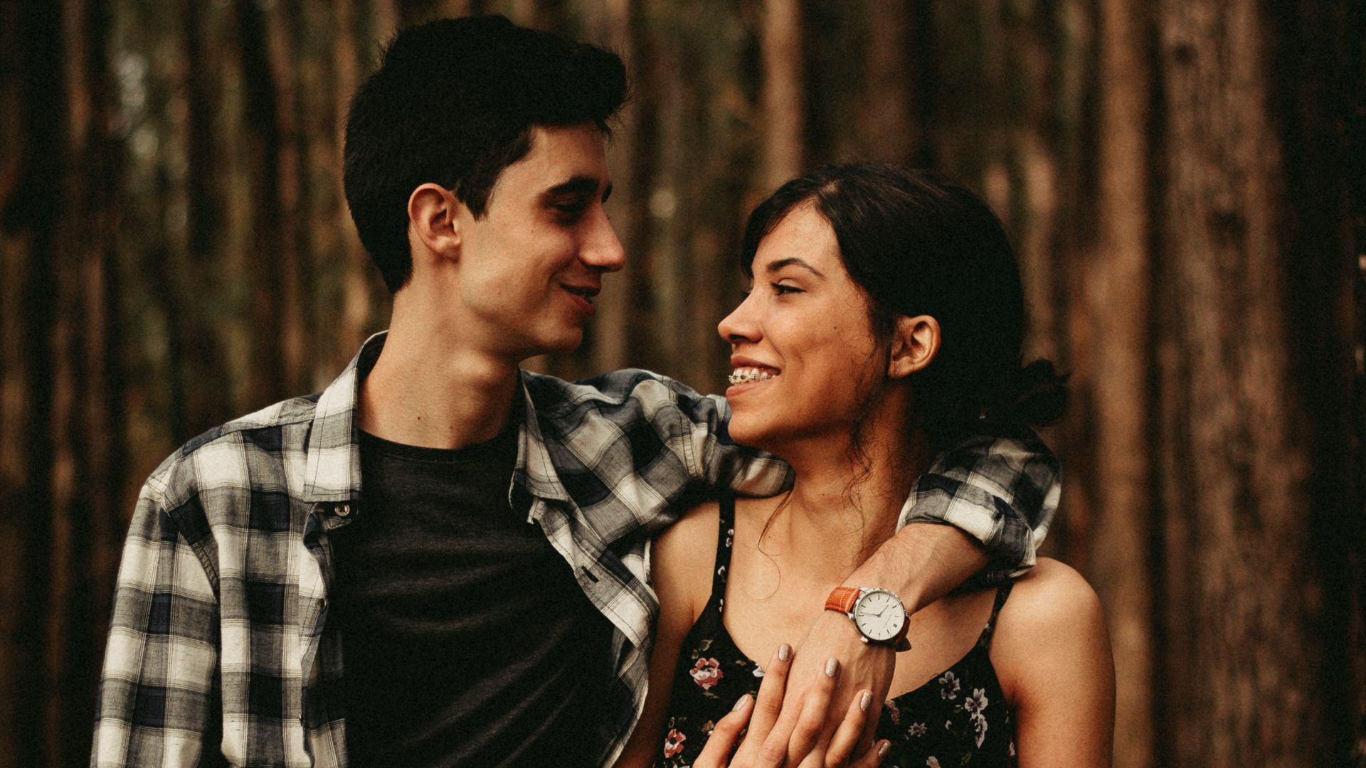 man wrapping arm on woman facing each other