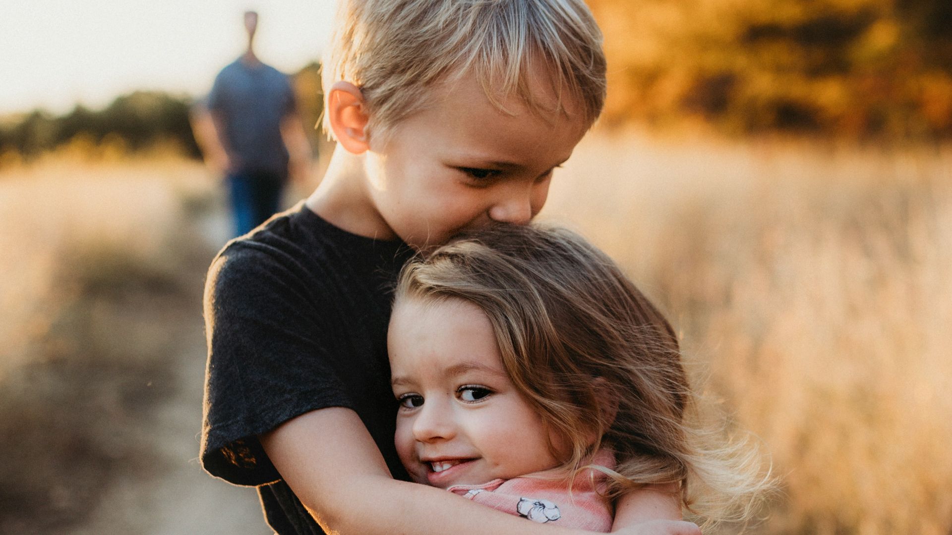 boy in black t-shirt hugging girl in red and white polka dot dress