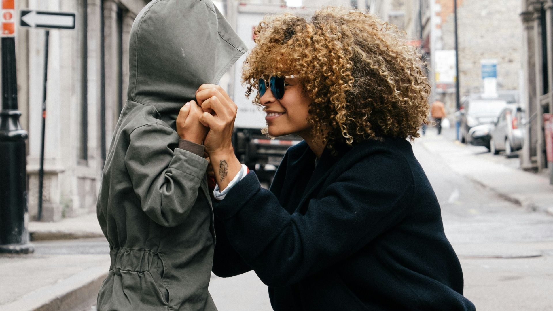 woman holding kid at the street