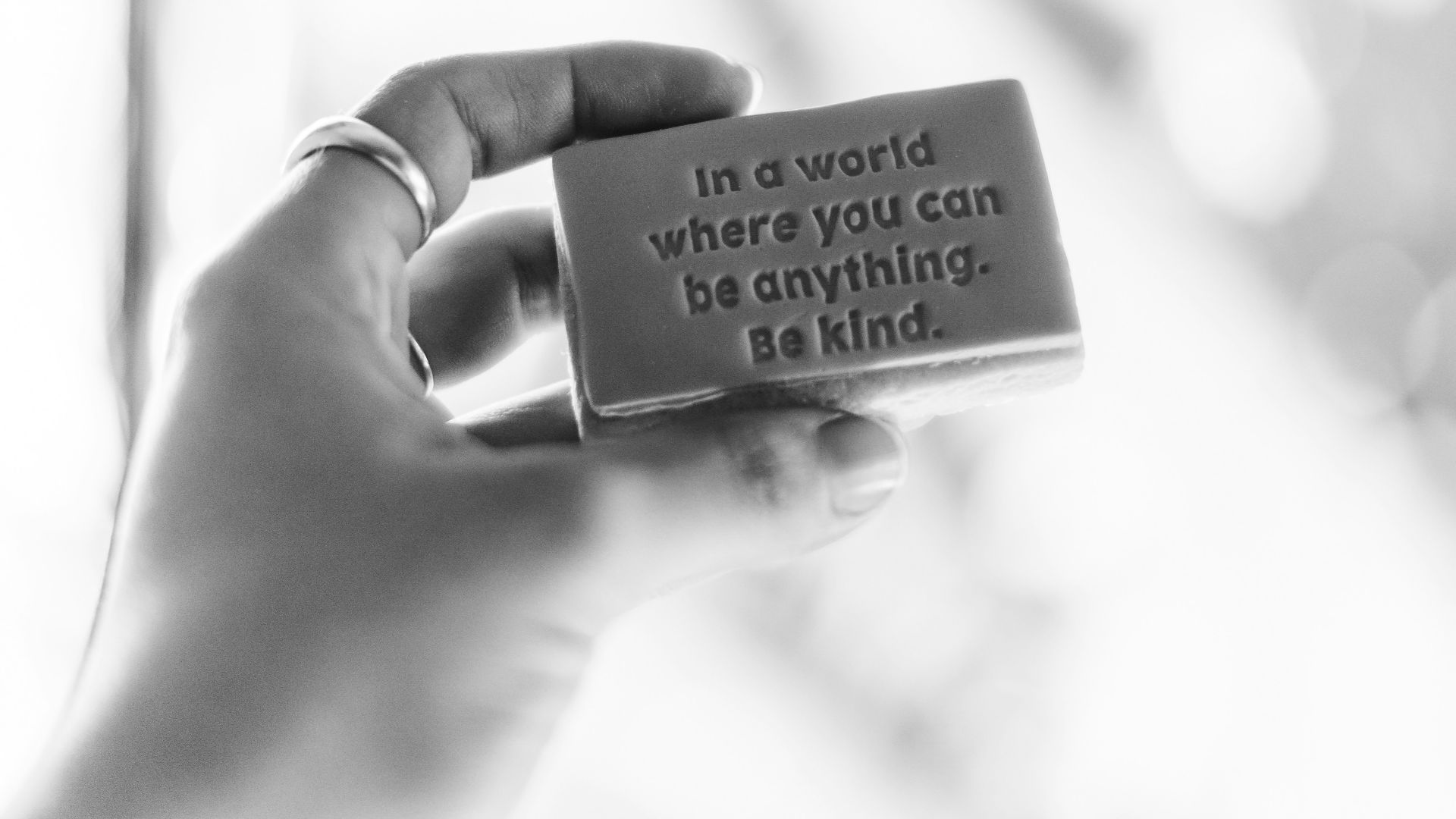 grayscale photo of person holding quote board