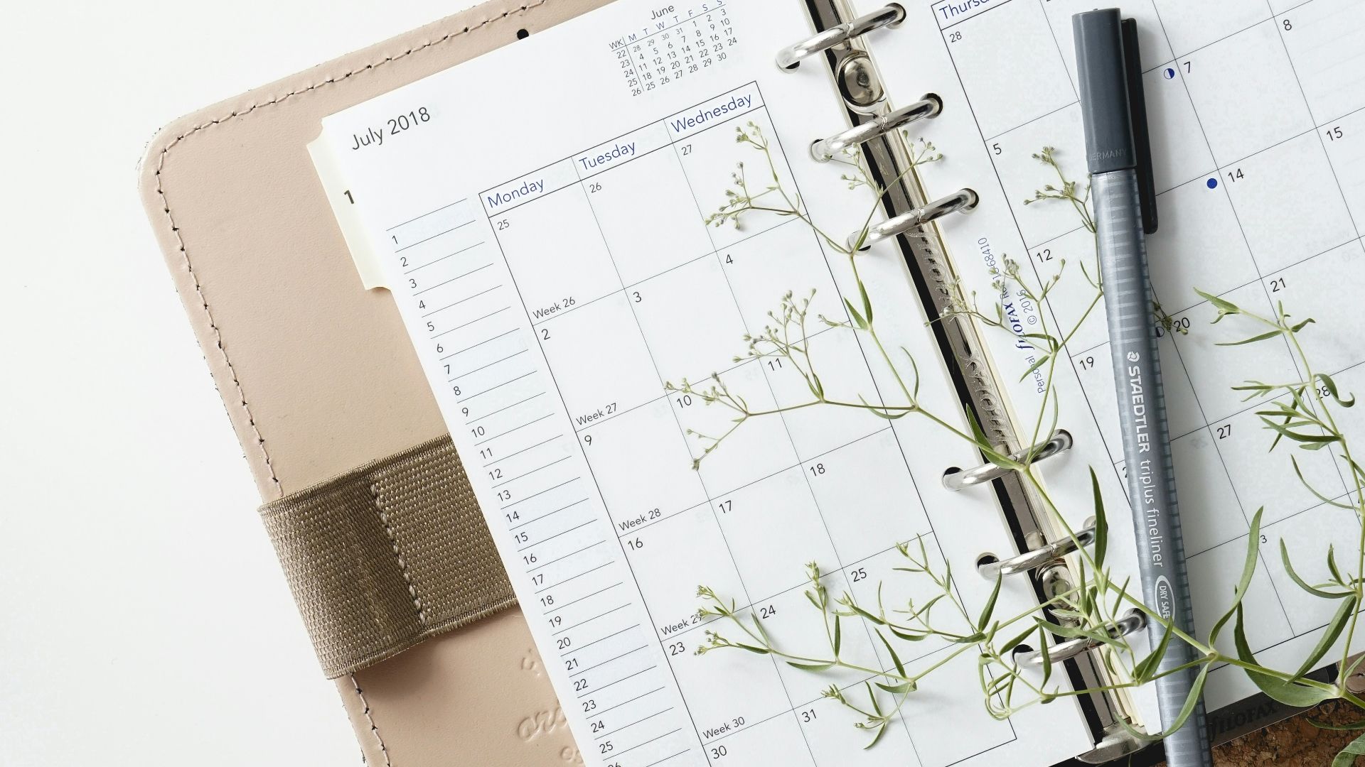 grey and black pen on calendar book