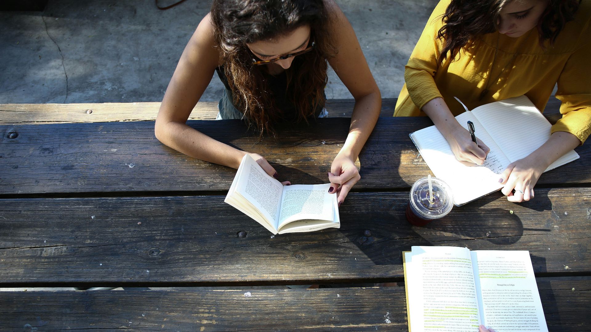 woman reading book while sitting on chair