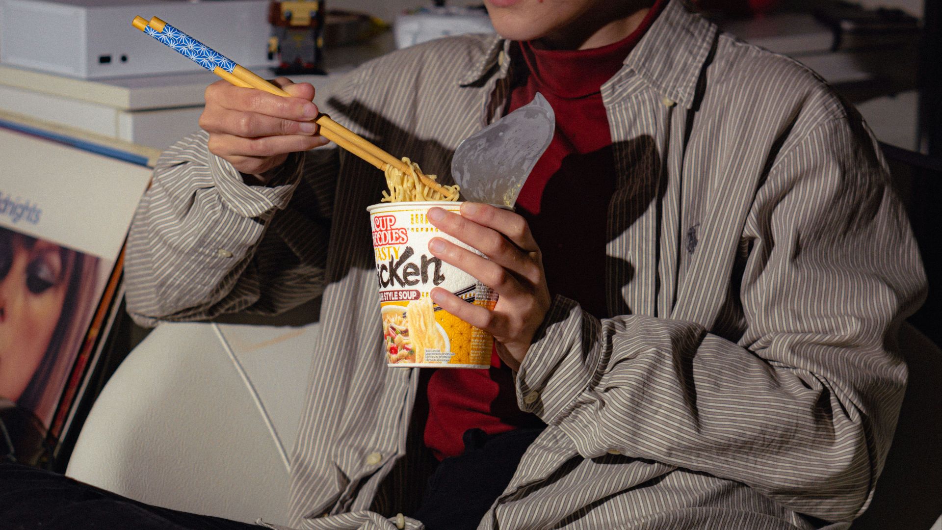 a man holding a cup of cereal and a toothbrush