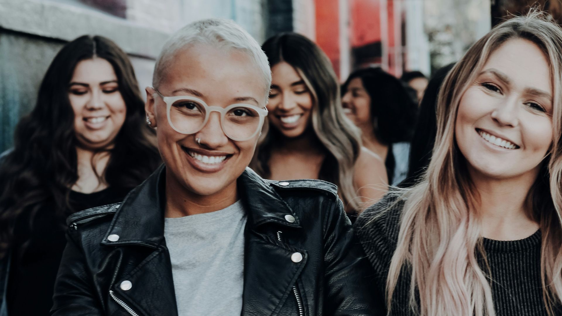 man in black leather jacket beside woman in black and white stripe shirt