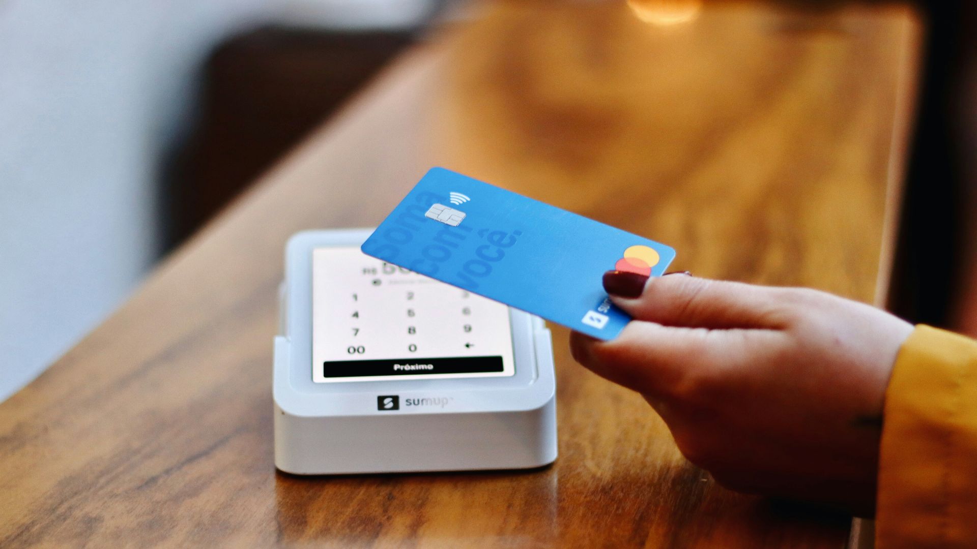 a person holding a credit card in front of a machine