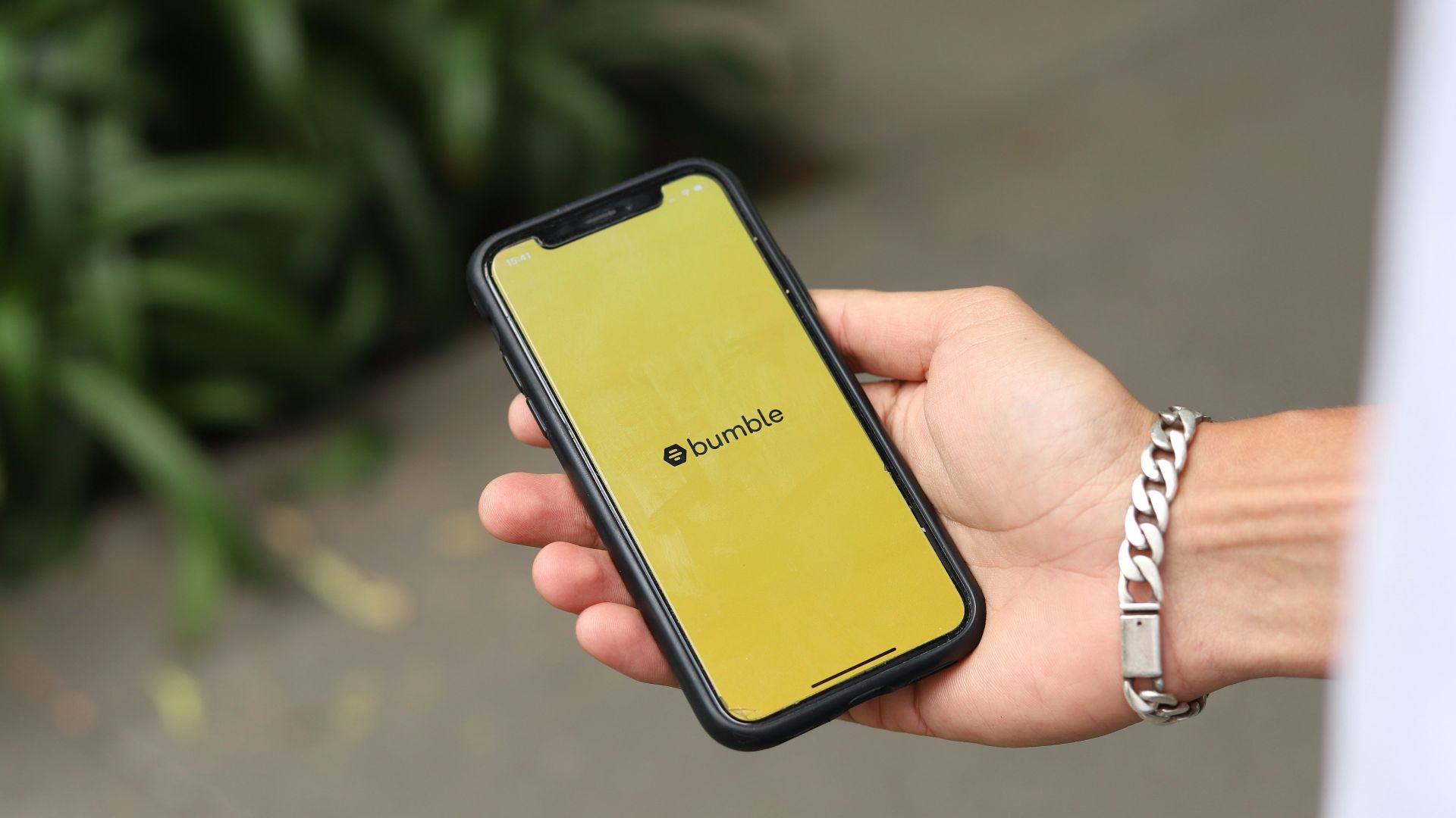 a person holding a yellow cell phone in their hand