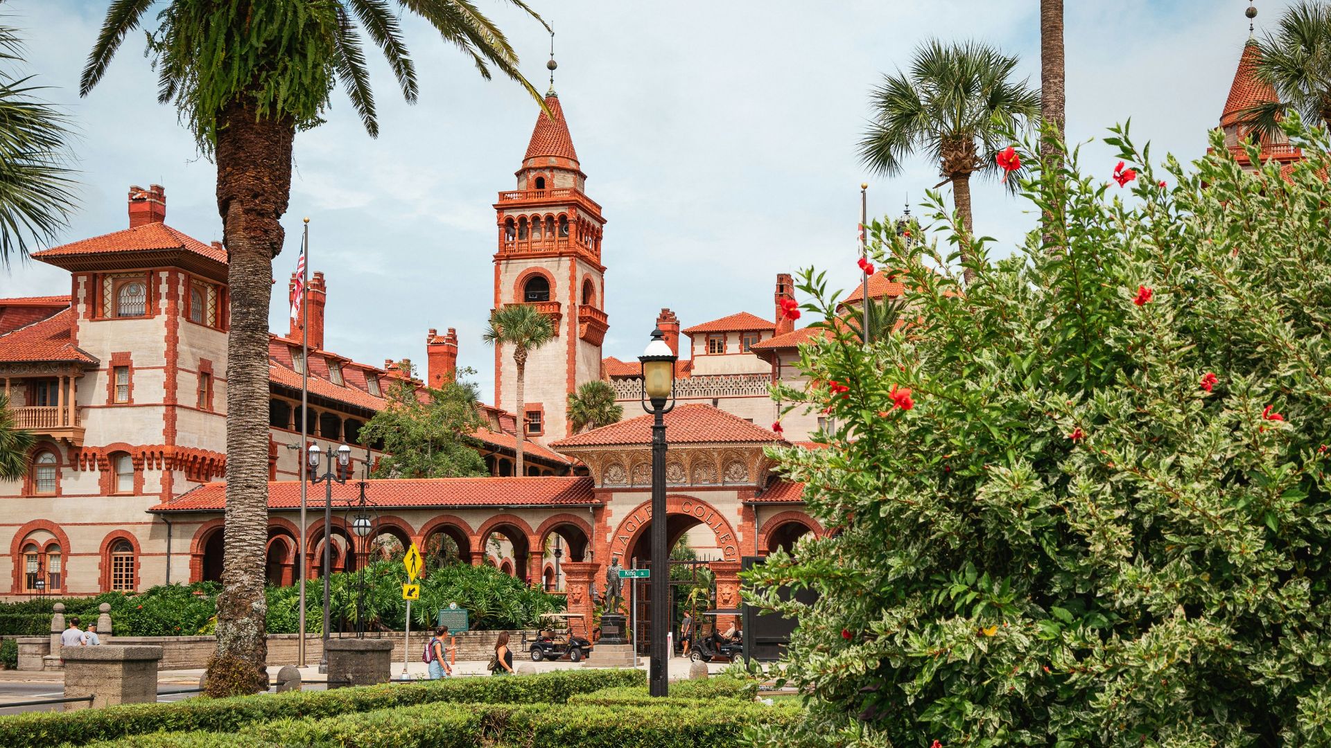A large building with a clock tower next to a lush green park