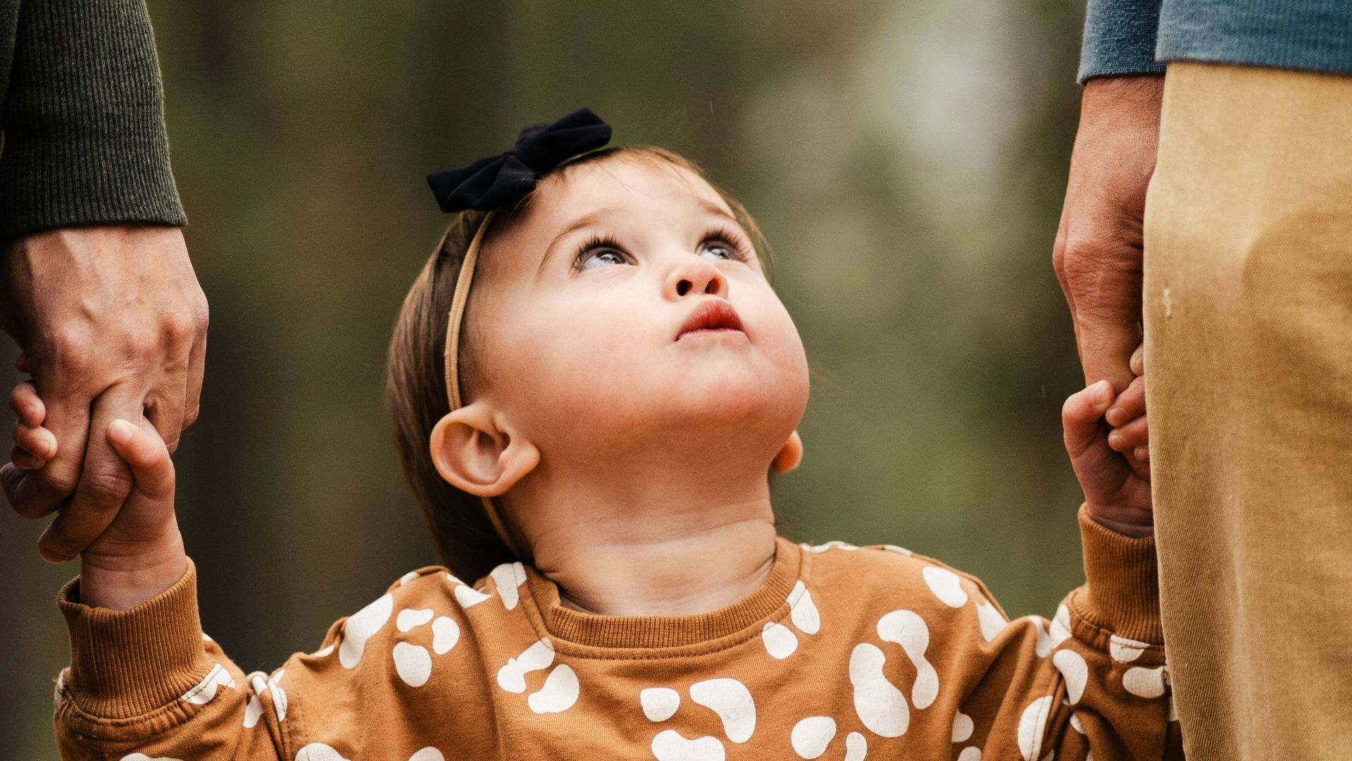 a little girl holding the hand of a man