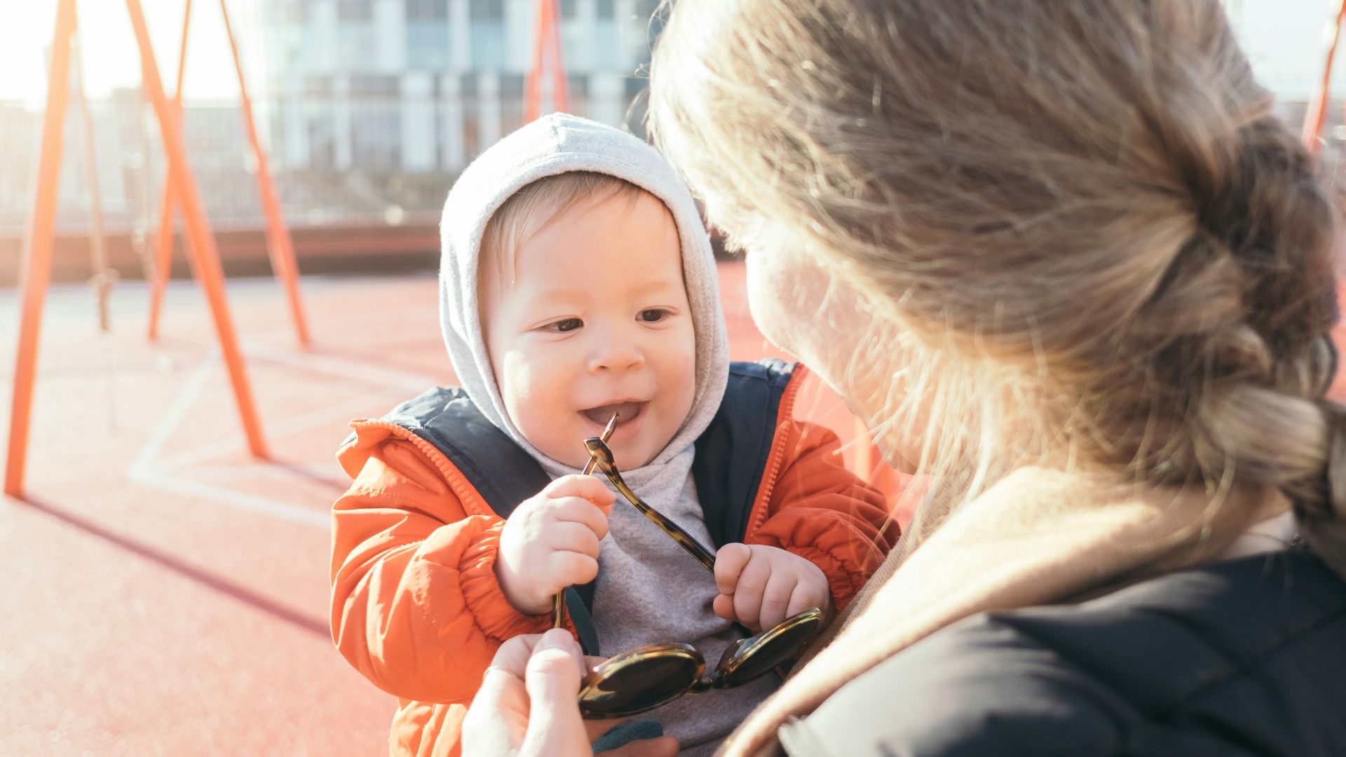 woman holding toddler on carrier