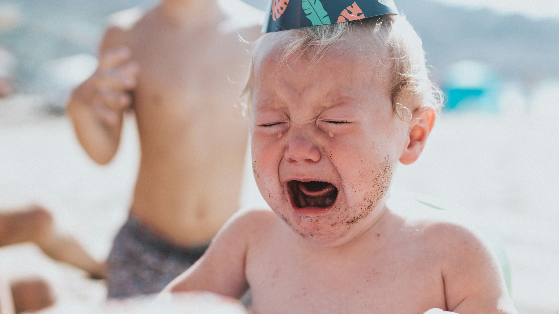 topless boy in blue and white floral shorts sitting on white and blue inflatable pool during