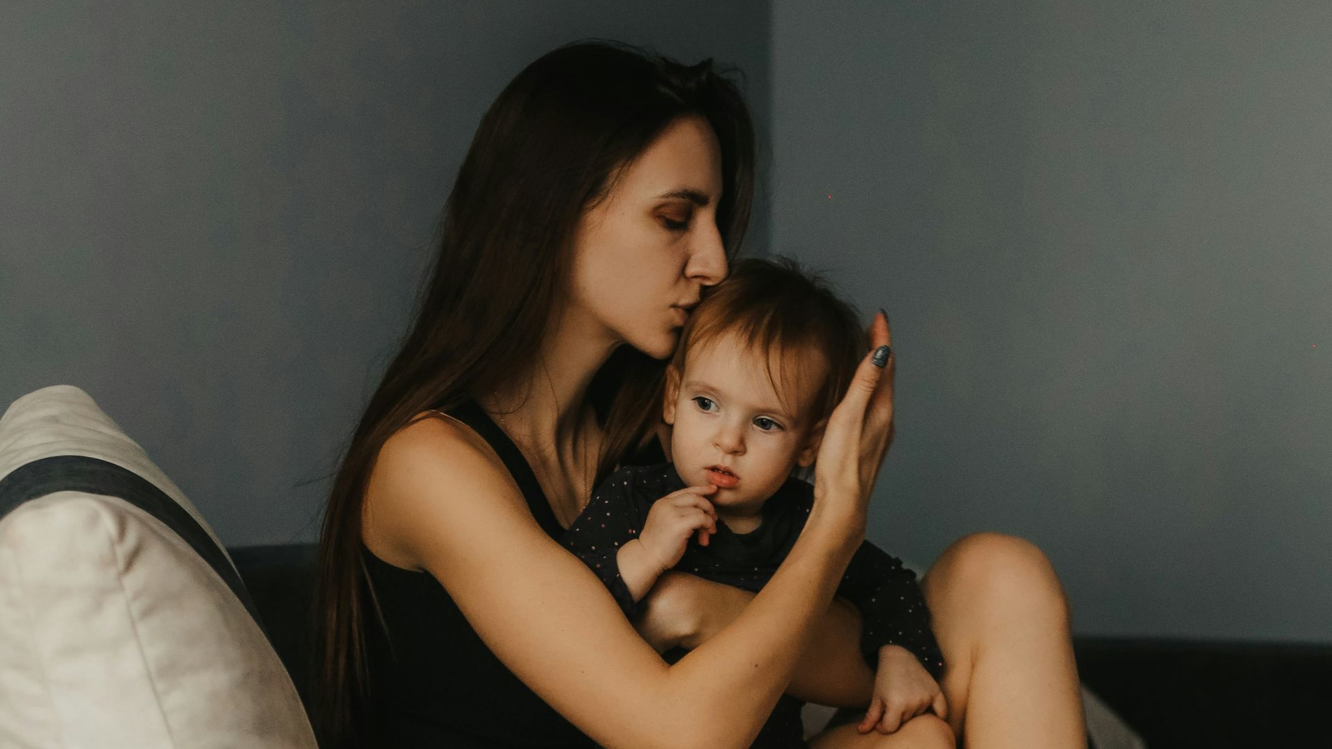 a woman sitting on a couch with a baby