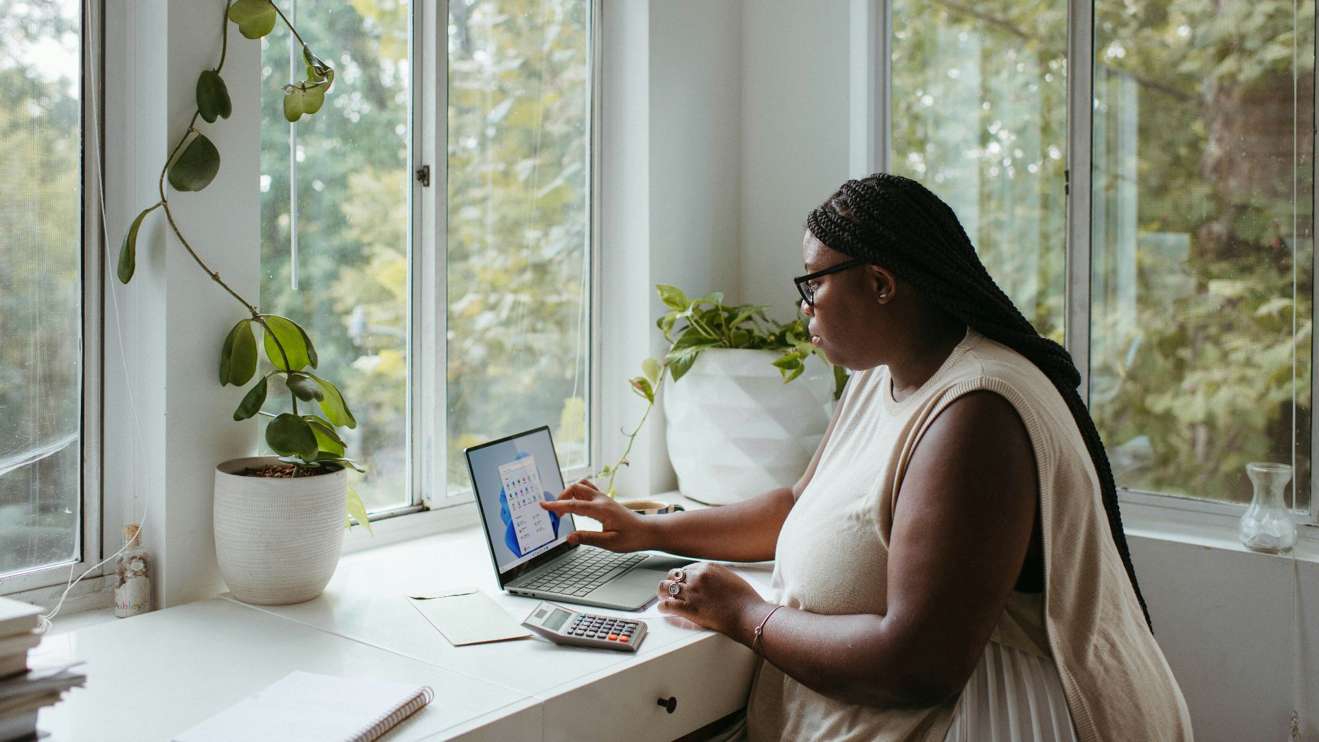 a woman sitting at a table with a laptop