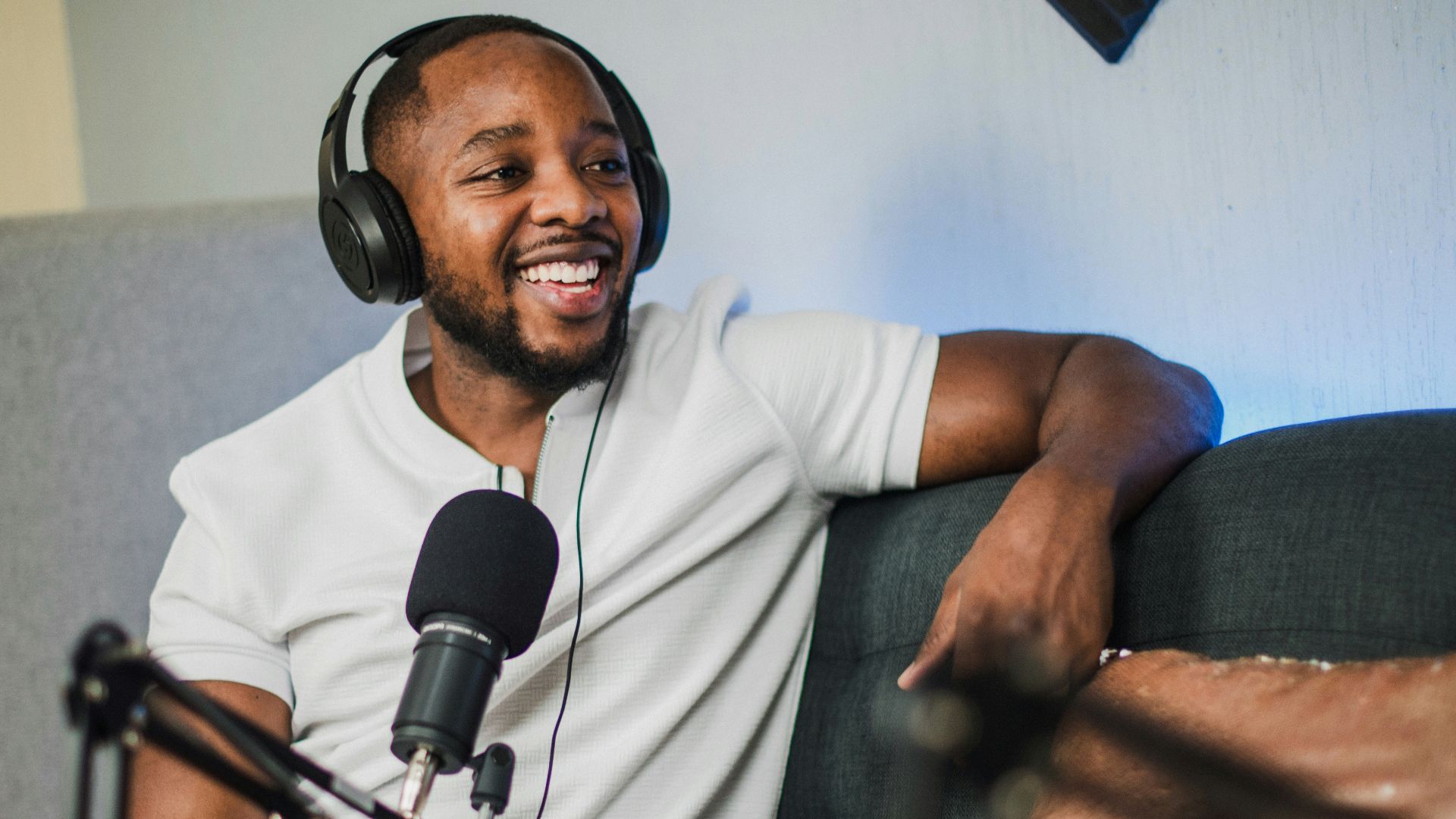 a man wearing headphones sitting in front of a microphone