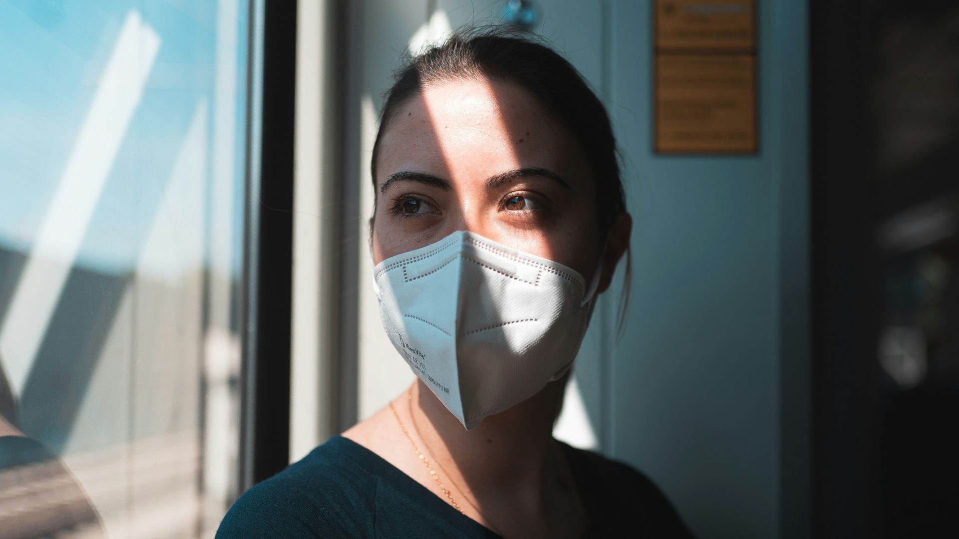 woman in black v neck shirt with white face mask