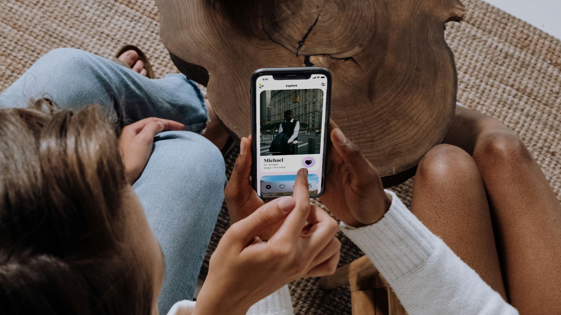 two women sitting on a couch looking at a cell phone