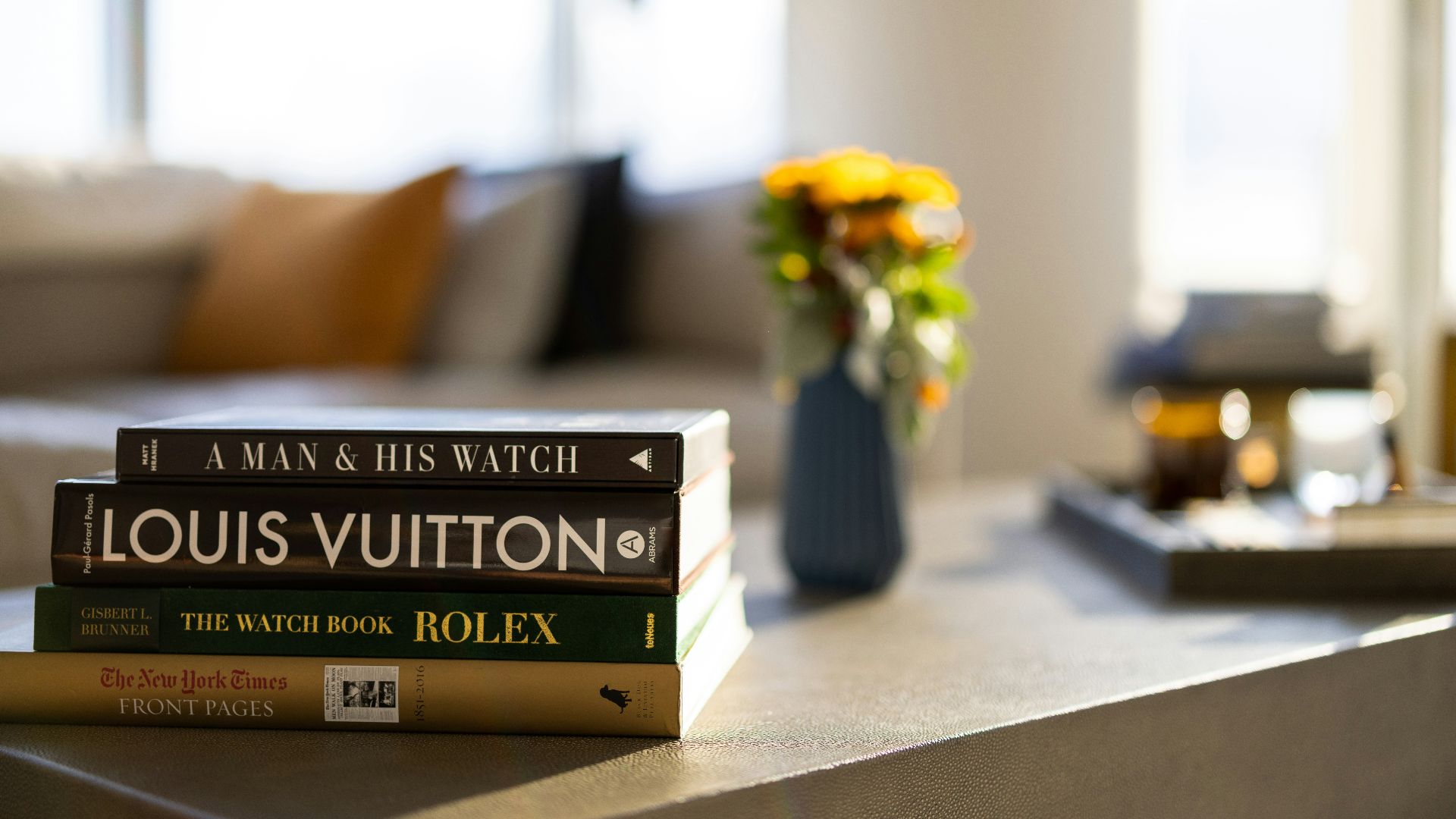 a vase of yellow flowers sits on top of a stack of books