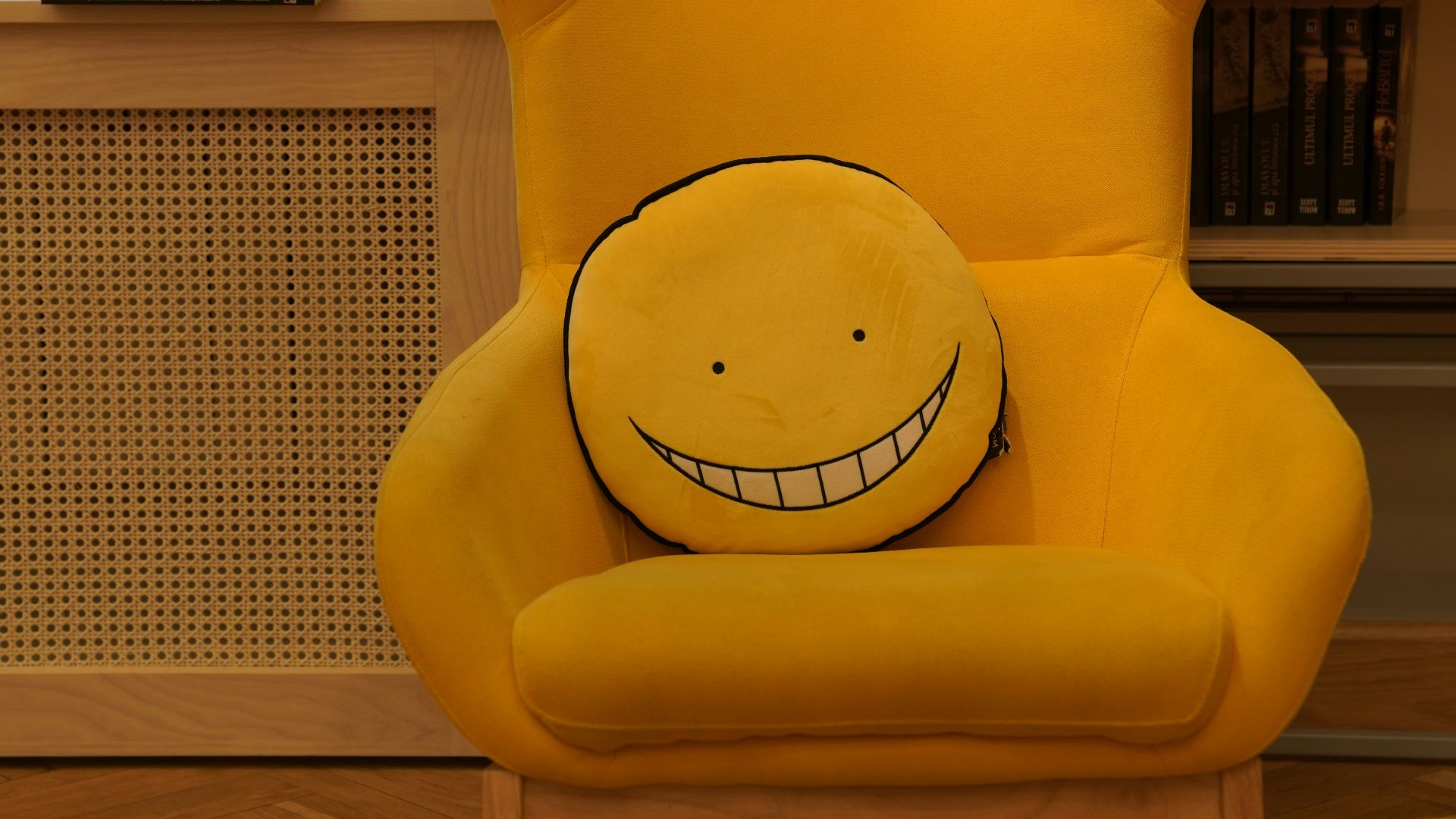 a yellow chair in front of a bookshelf