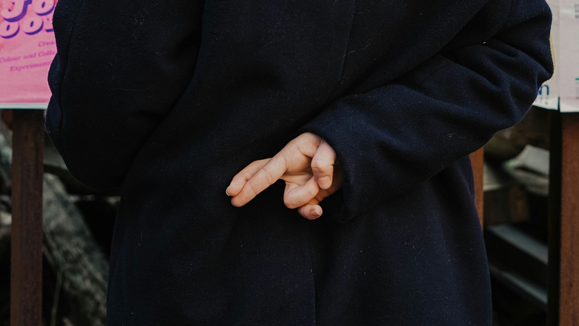 woman in blue hoodie standing in front of white and red kanji text signage