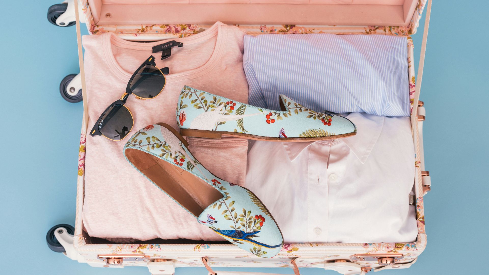 clothing items and pair of shoes in luggage
