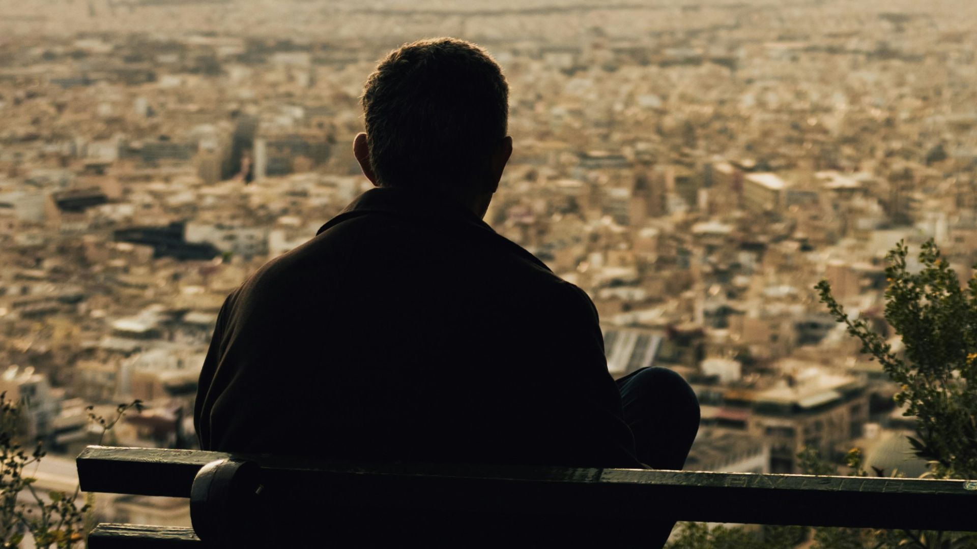 silhouette of man sitting on bench during sunset