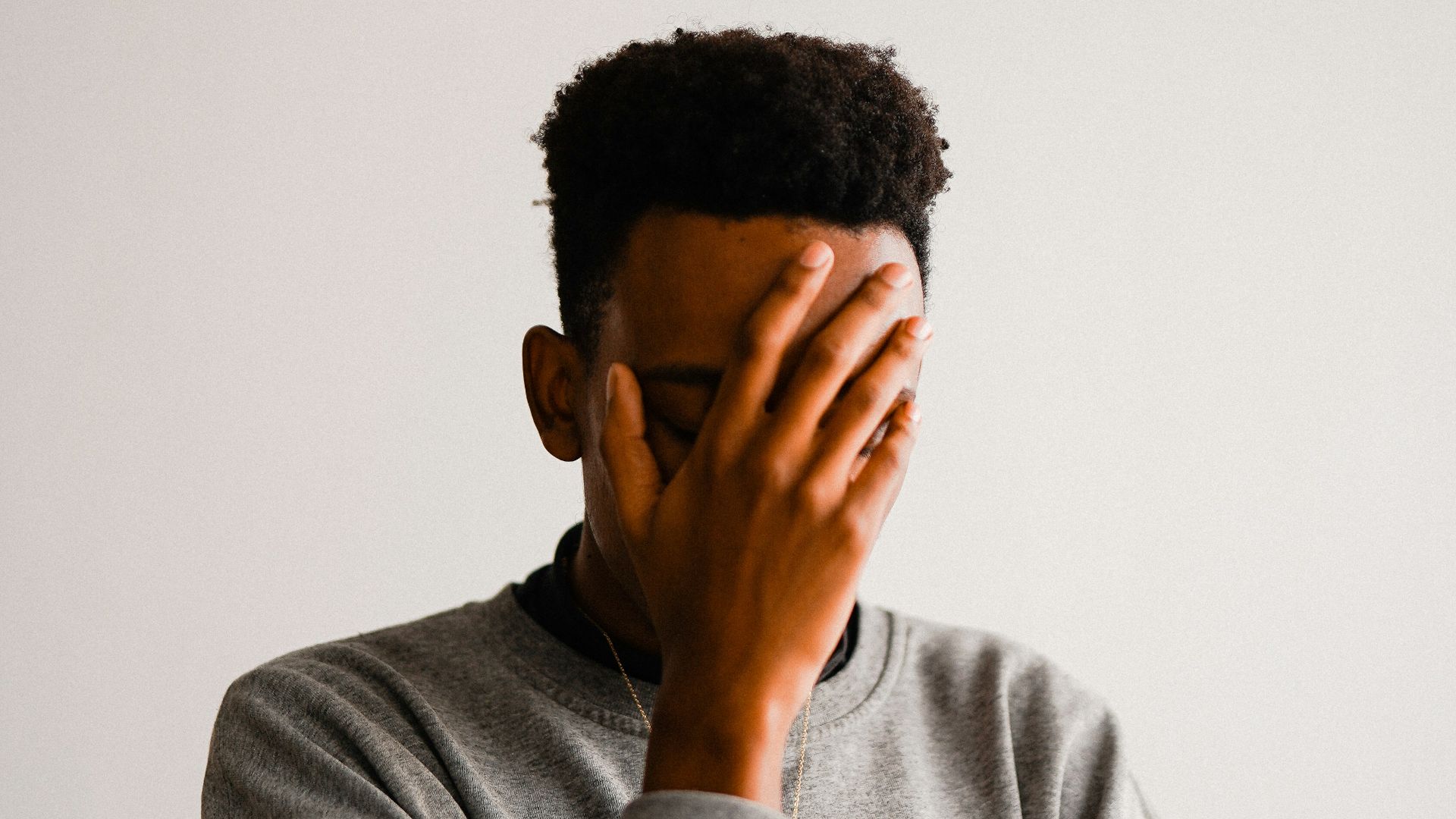 a man covering his face with his hands