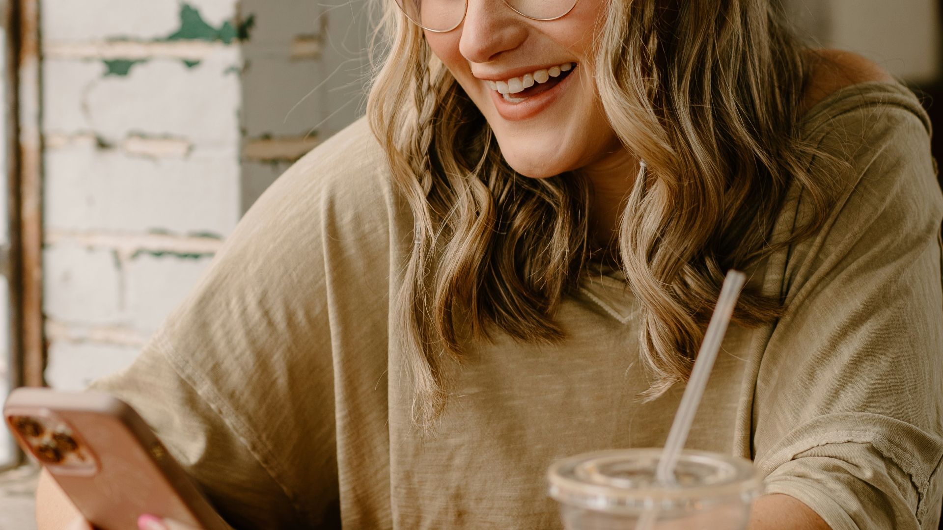 a woman sitting at a table looking at her phone