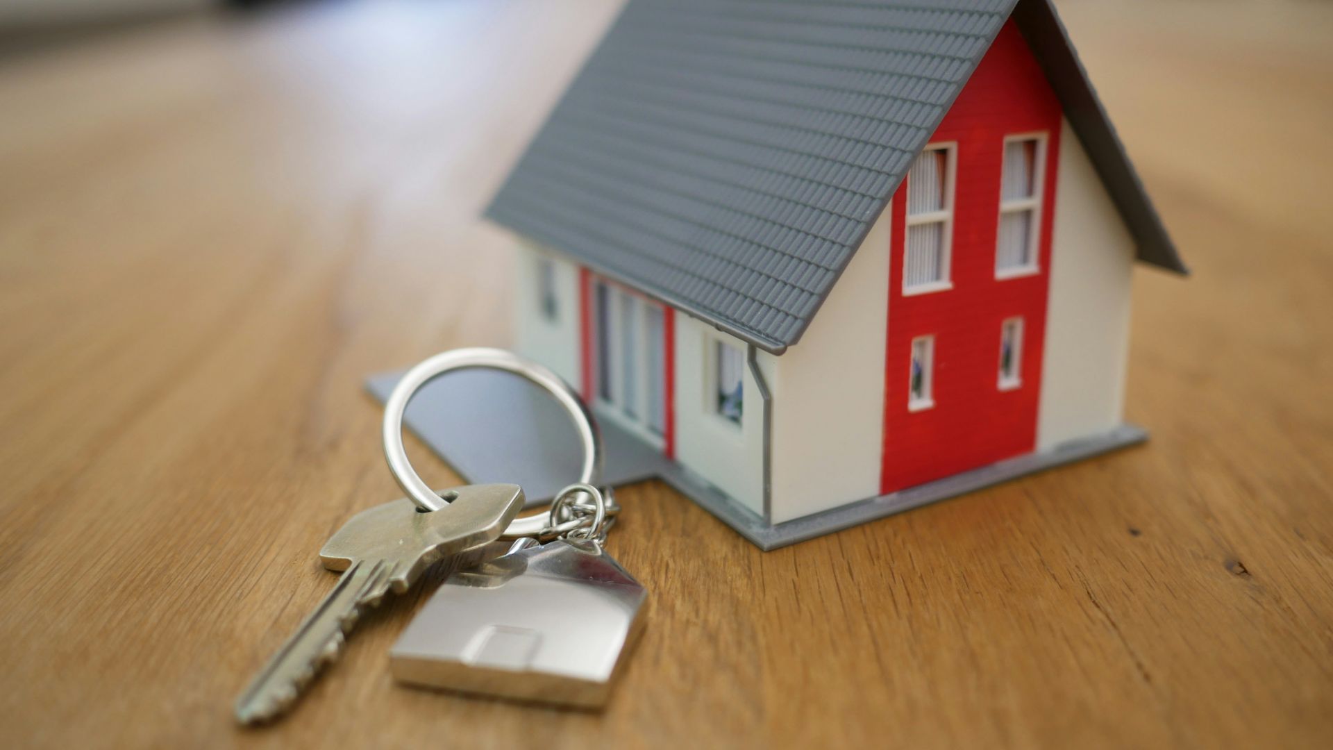 white and red wooden house miniature on brown table