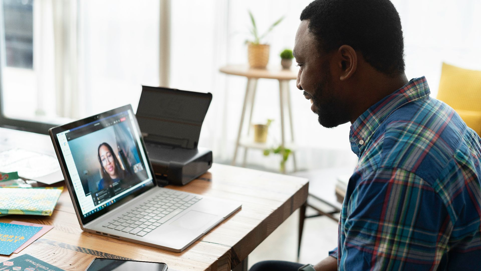 man in blue and white plaid dress shirt using macbook pro