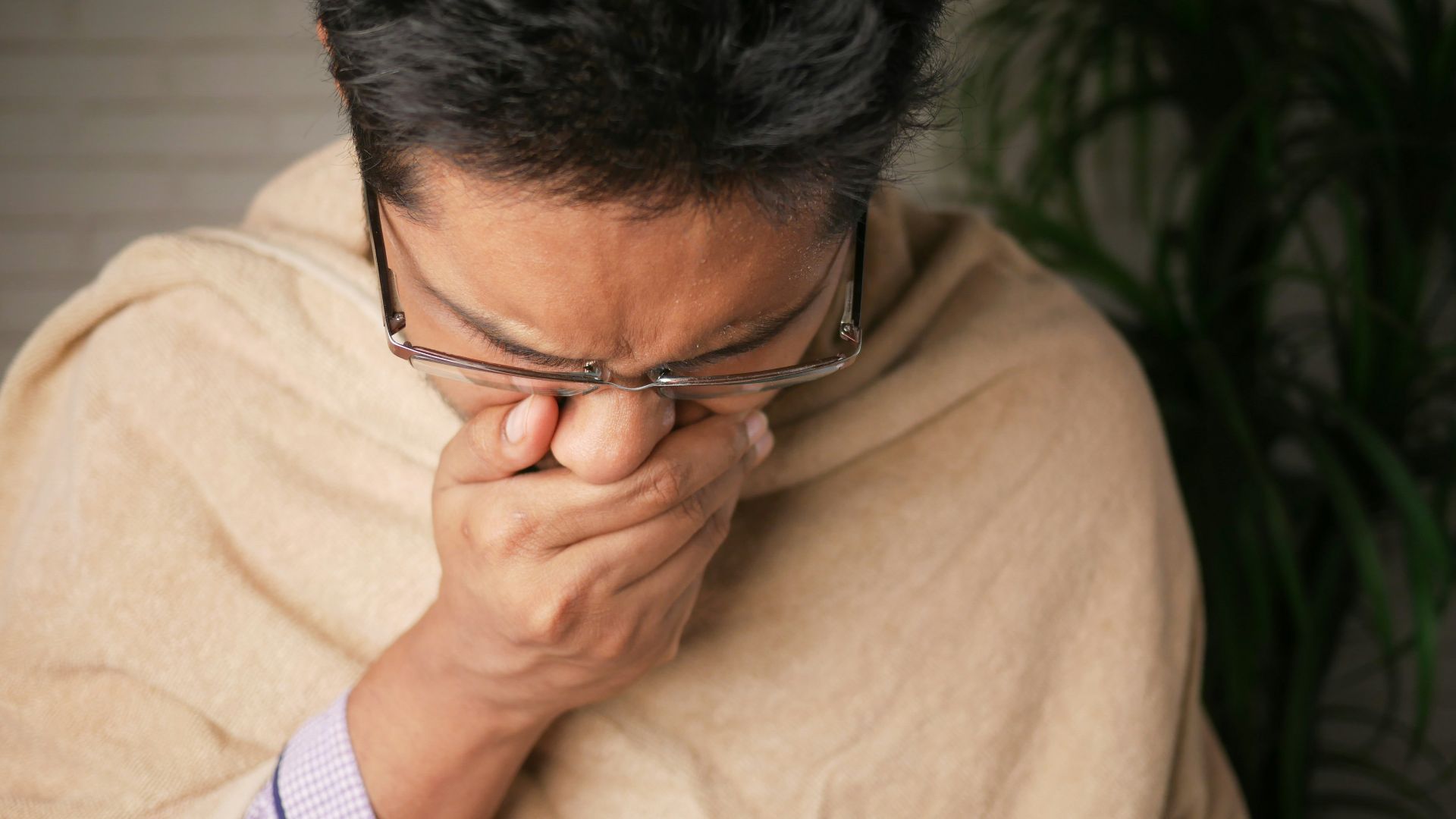 man in brown sweater wearing black framed eyeglasses